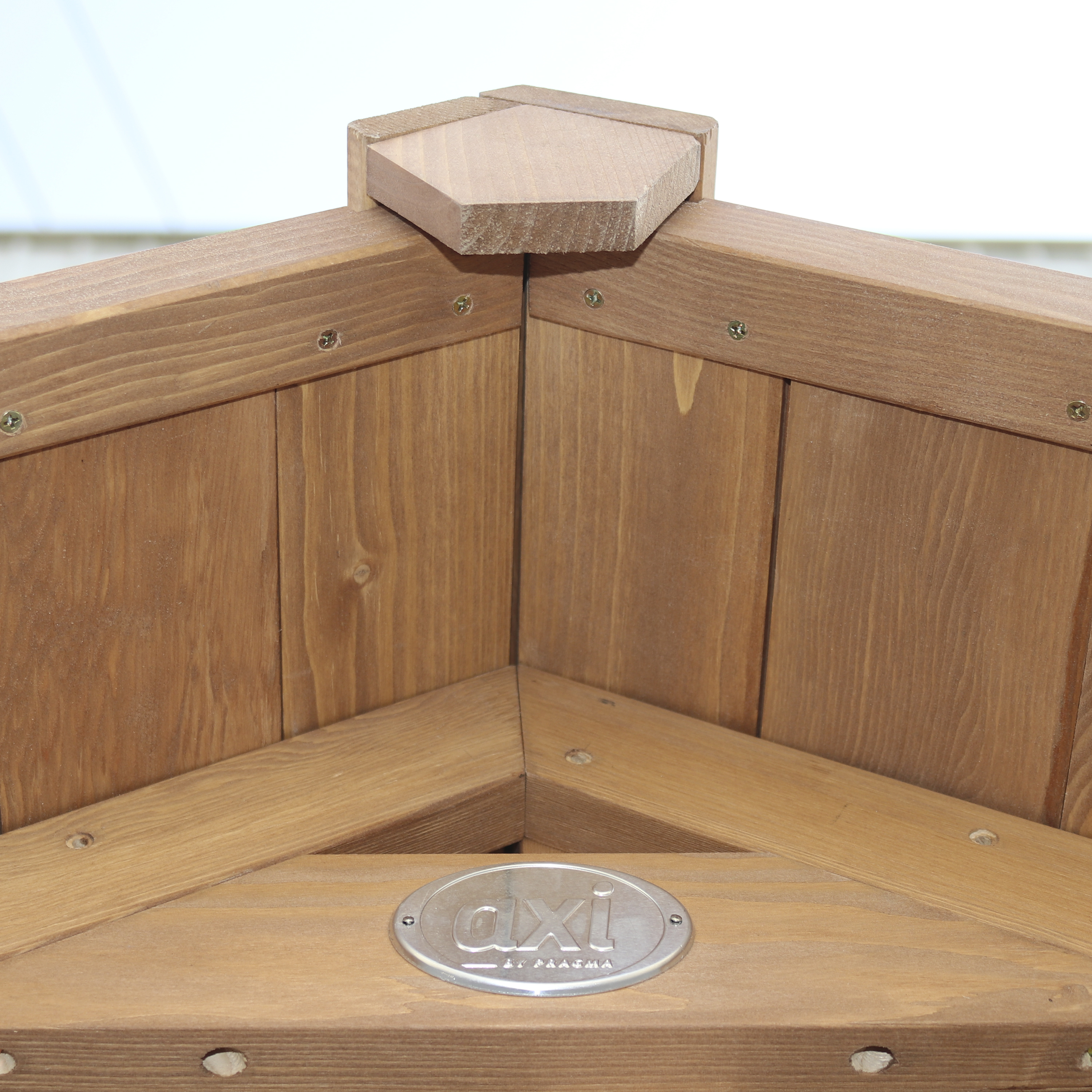 Eckkonstruktion aus Holz. Das Holz ist braun und hat ein Metalllogo. Der Hintergrund ist unscharf.