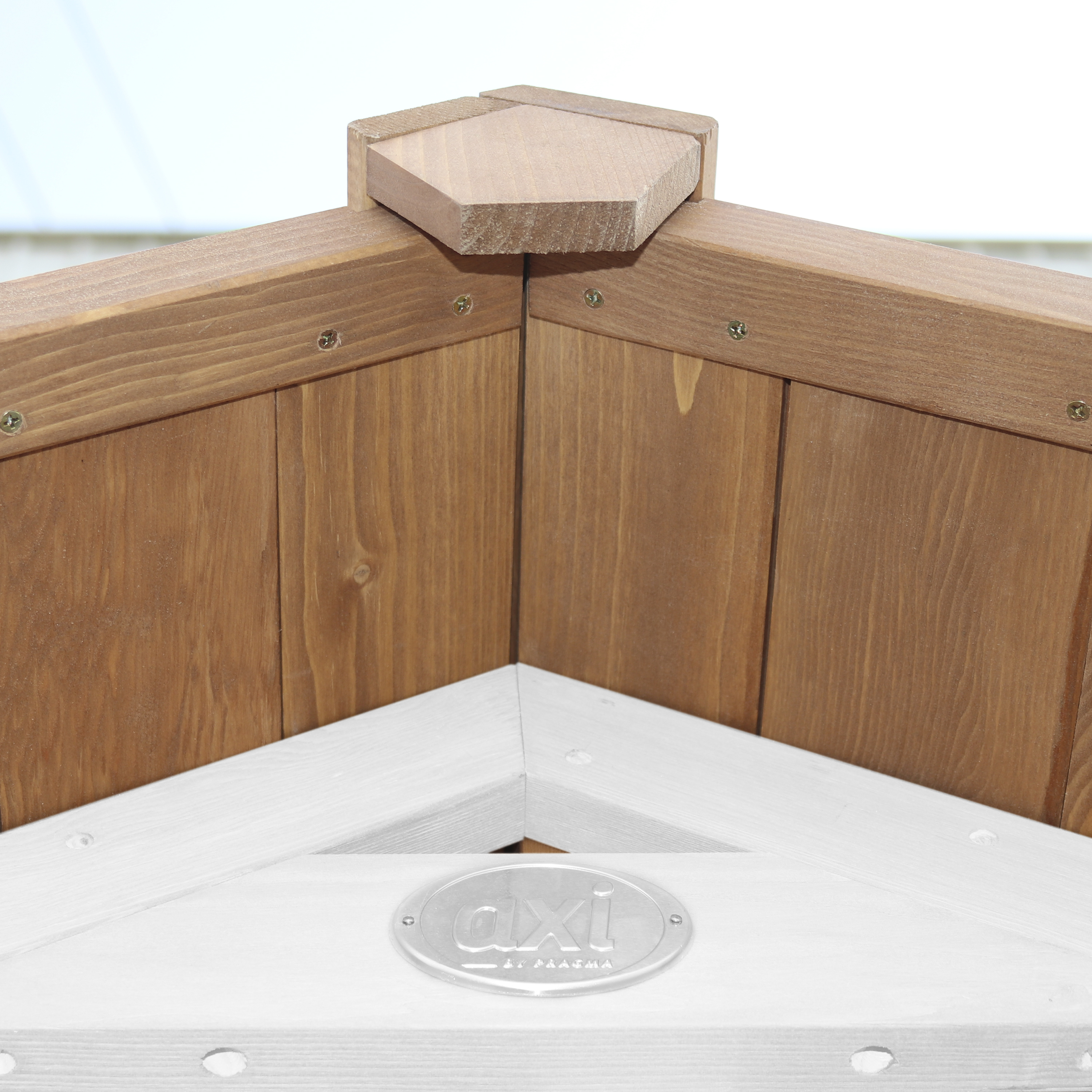 Nahaufnahme einer Holzecke. Helle Holzpaneele und ein weißer Rahmen mit Logo.