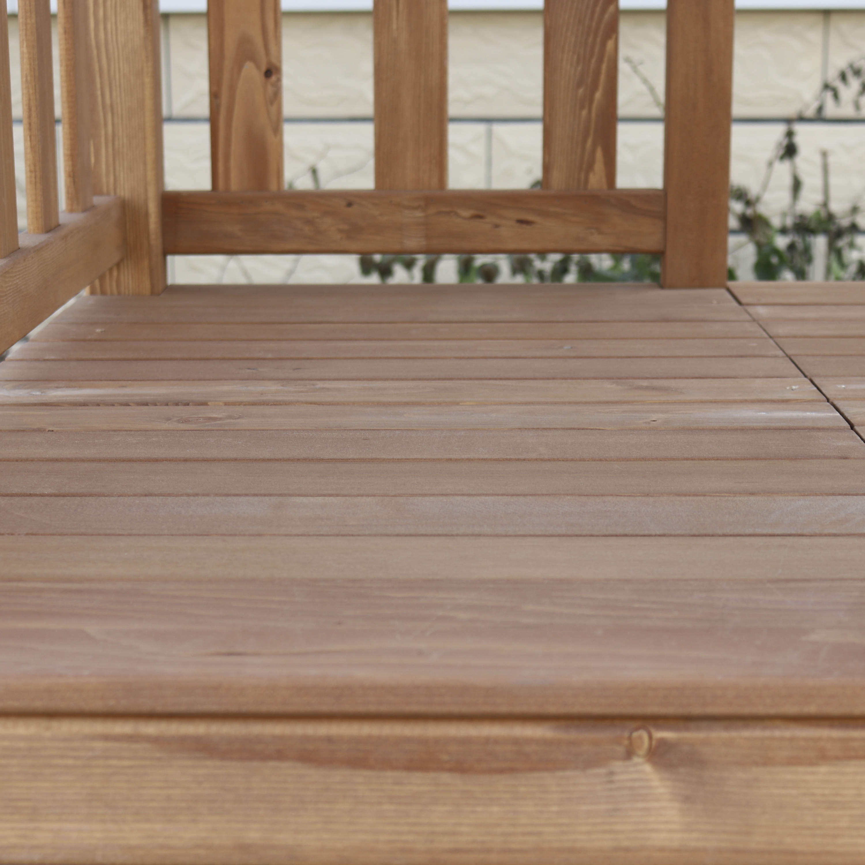 Eine Nahaufnahme eines Holzdecks. Das Holz hat eine natürliche, hellbraune Farbe.