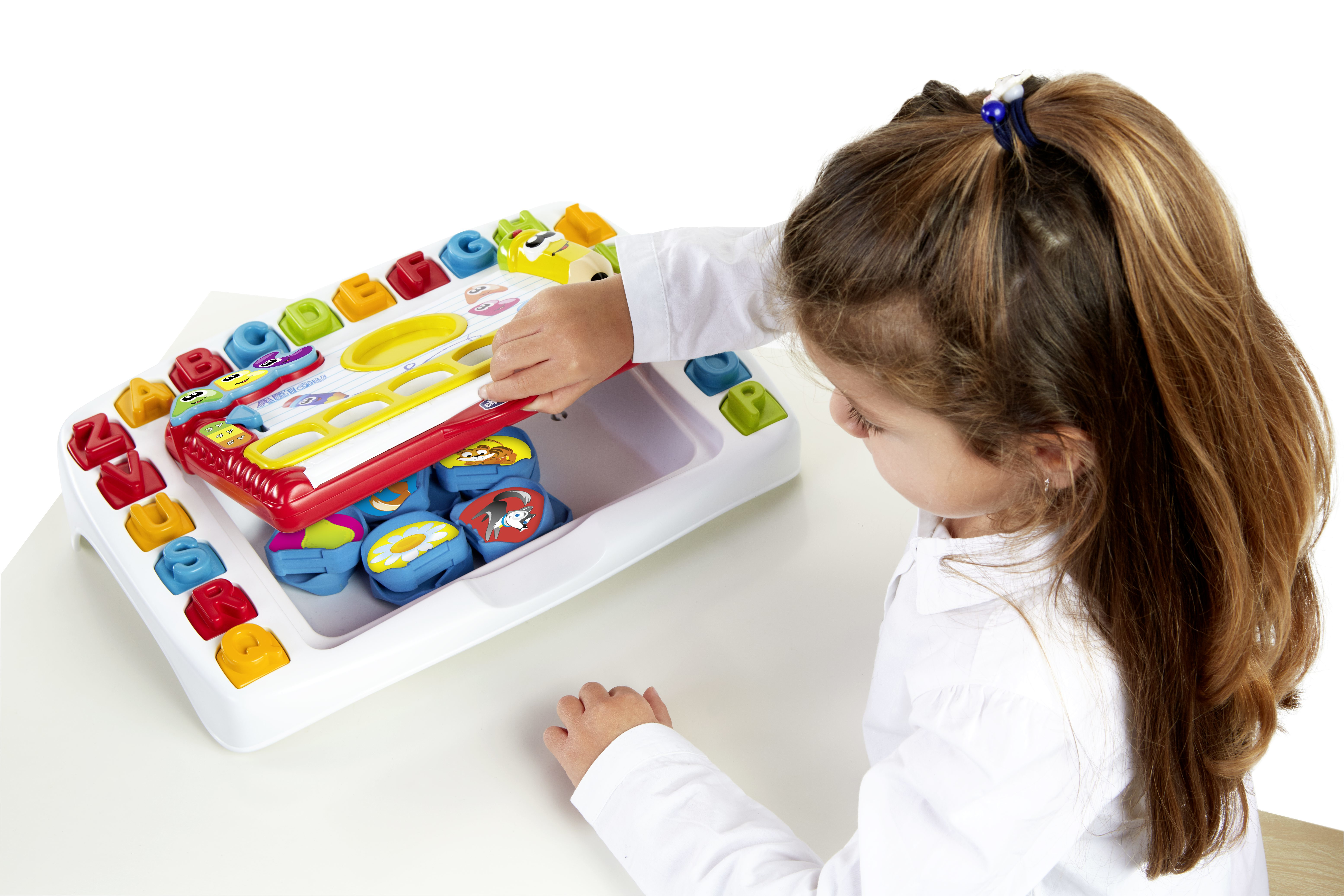Dziewczynka bawi się zabawką, urządzeniem edukacyjnym z kolorowymi przyciskami i kształtami.