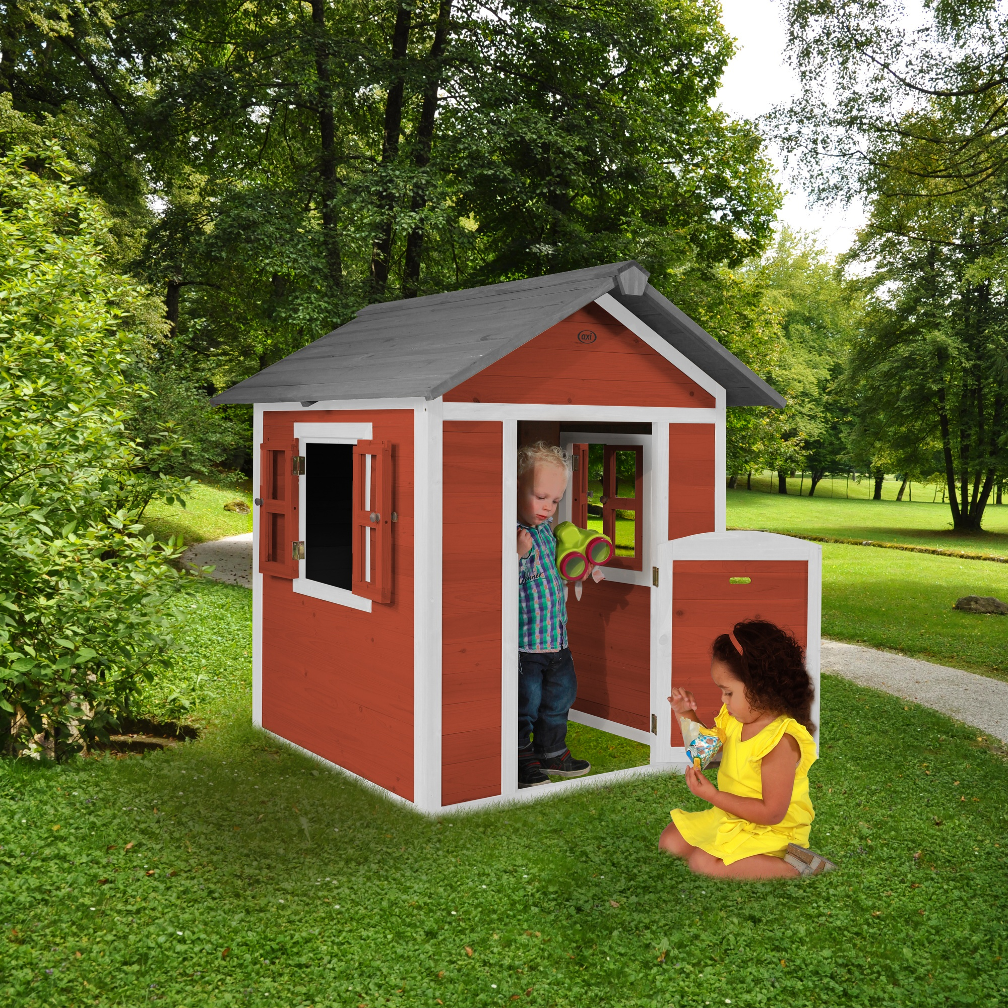 Kinder spielen in einem roten Spielhaus. Einer hält ein Fernglas, ein anderer spielt mit einem Spielzeug. Grünes Gras und Bäume umgeben es.