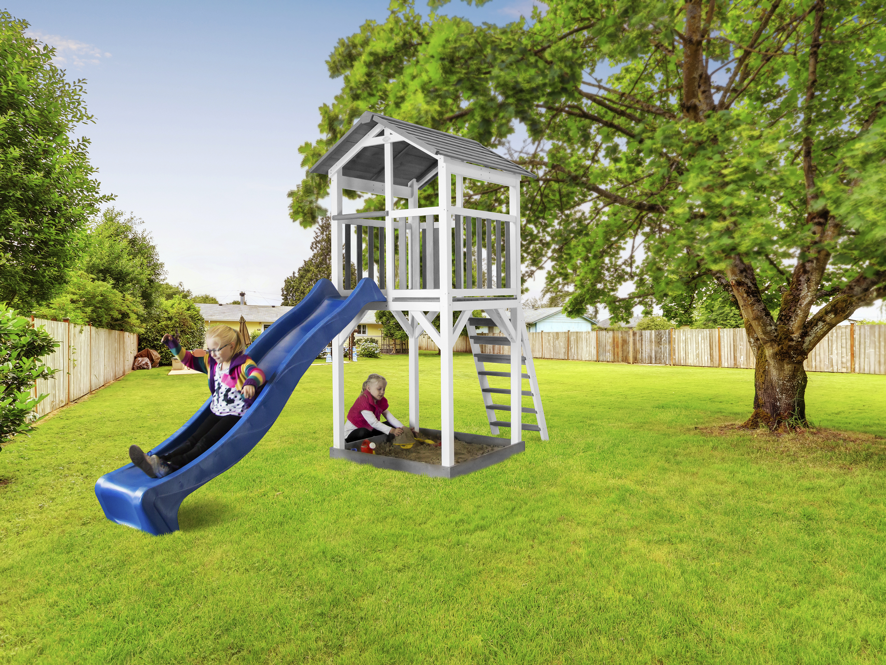 Zwei Kinder spielen auf einem Spielplatz mit Rutsche und Spielhaus. Grünes Gras.