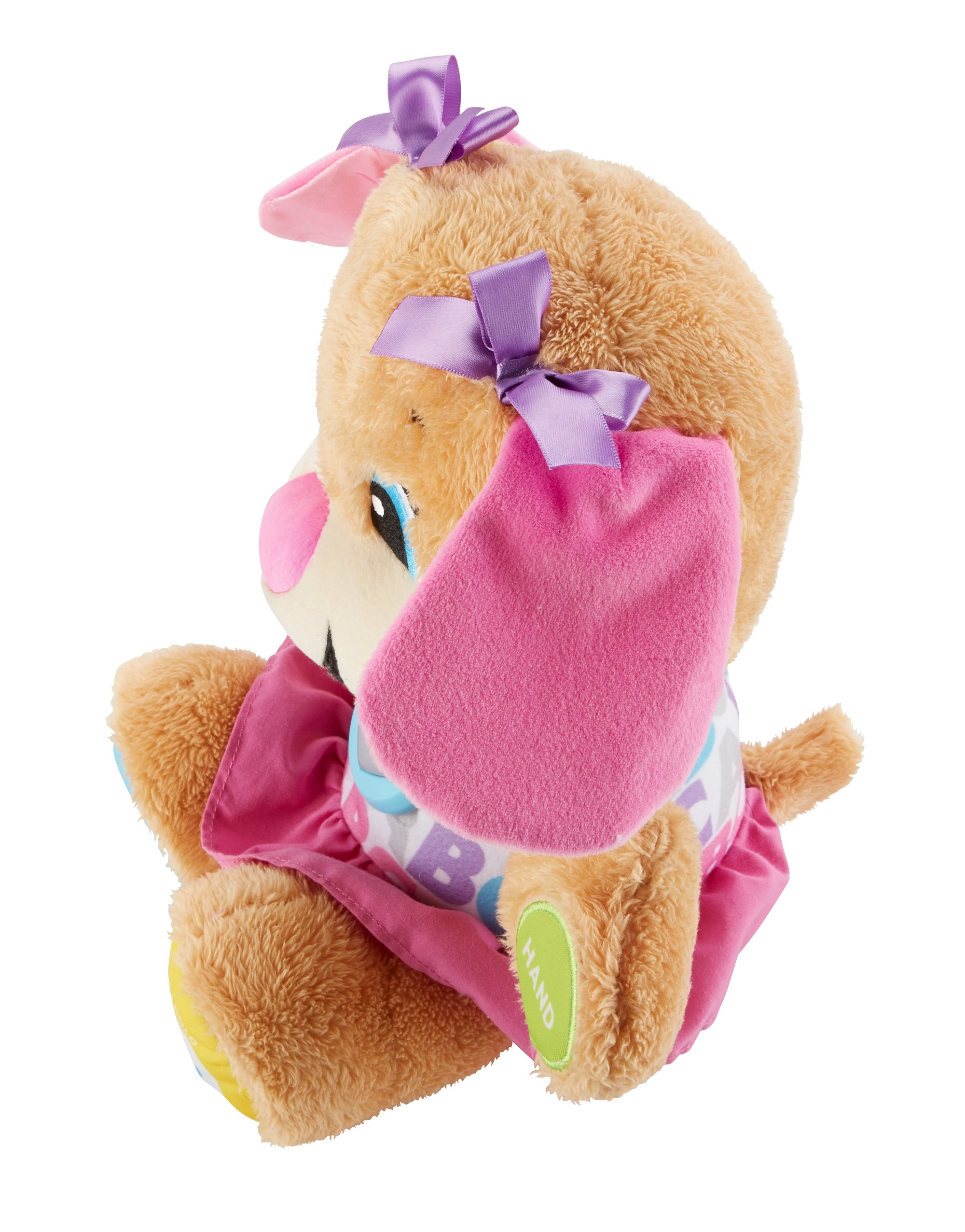 Juguete de peluche de perro con lazos morados y vestido rosa sentado.