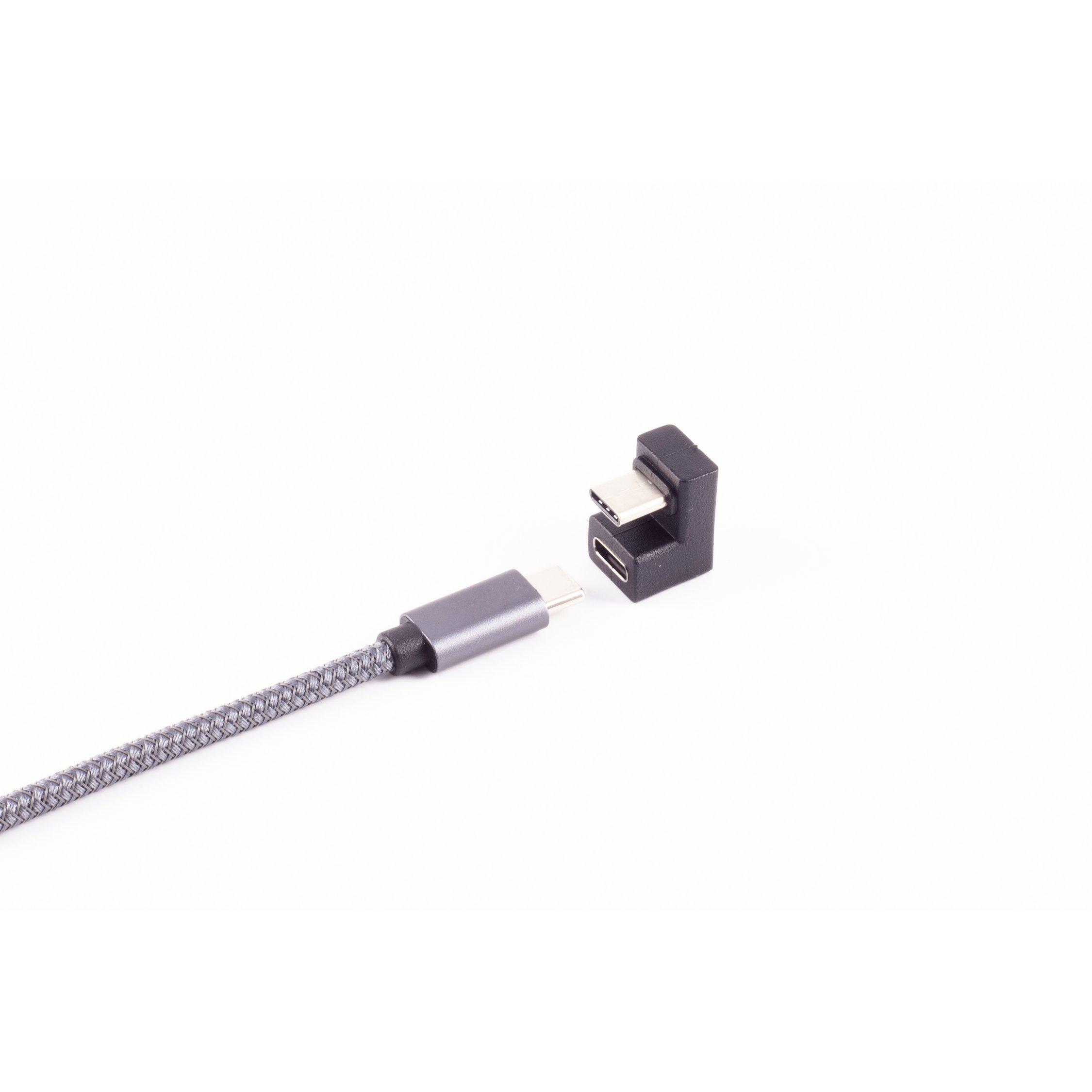 Un cavo USB-C e un adattatore USB-C a USB-C, entrambi grigi, giacciono su una superficie bianca.