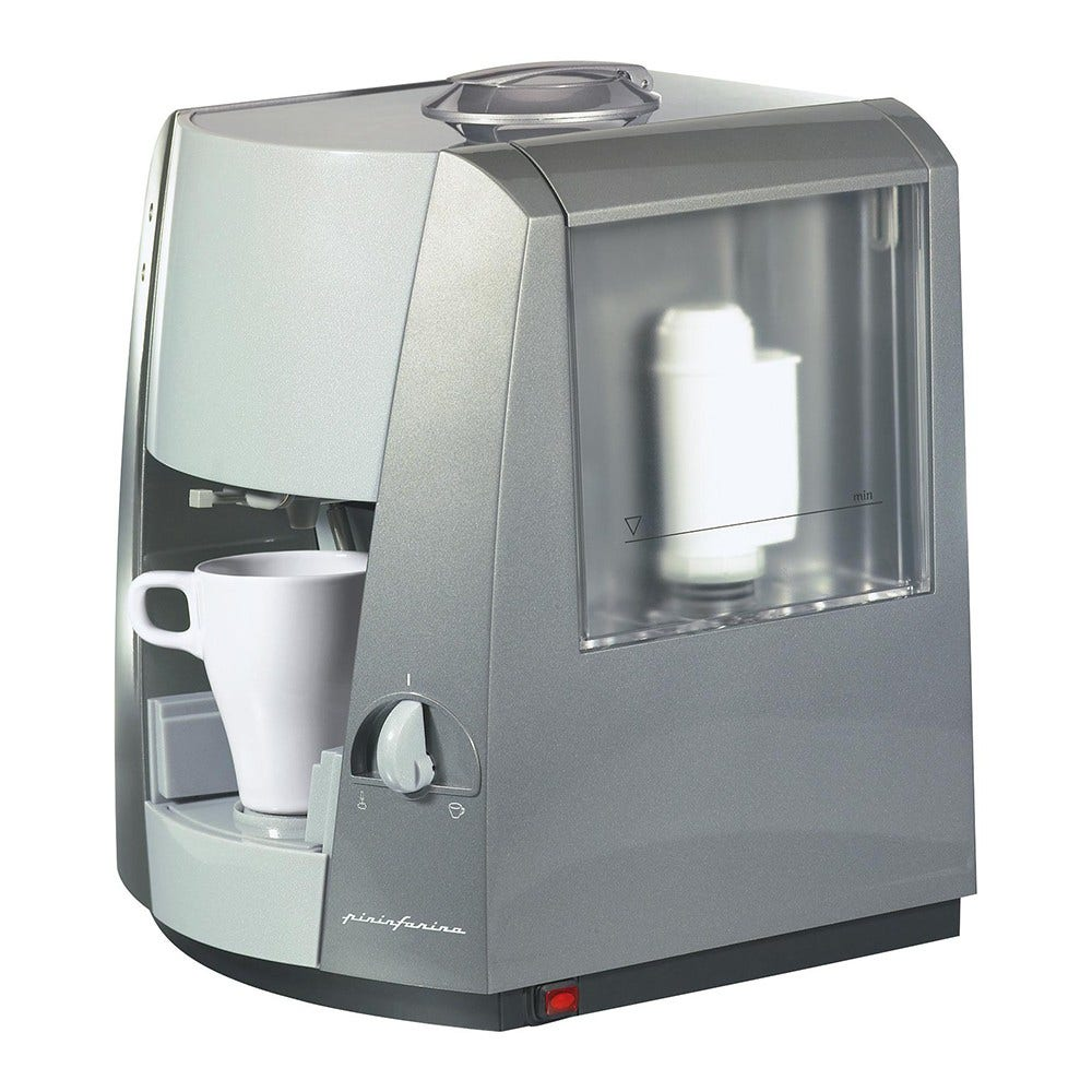 Silber-graue Kaffeemaschine mit einer weißen Tasse daneben.