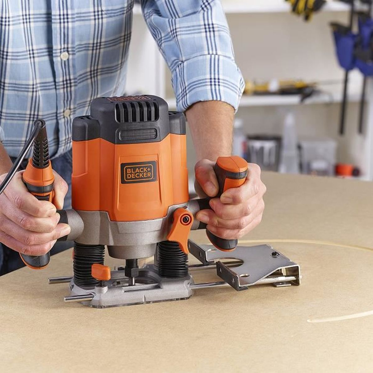 Persona usando fresadora Black+Decker para cortar forma circular en madera.