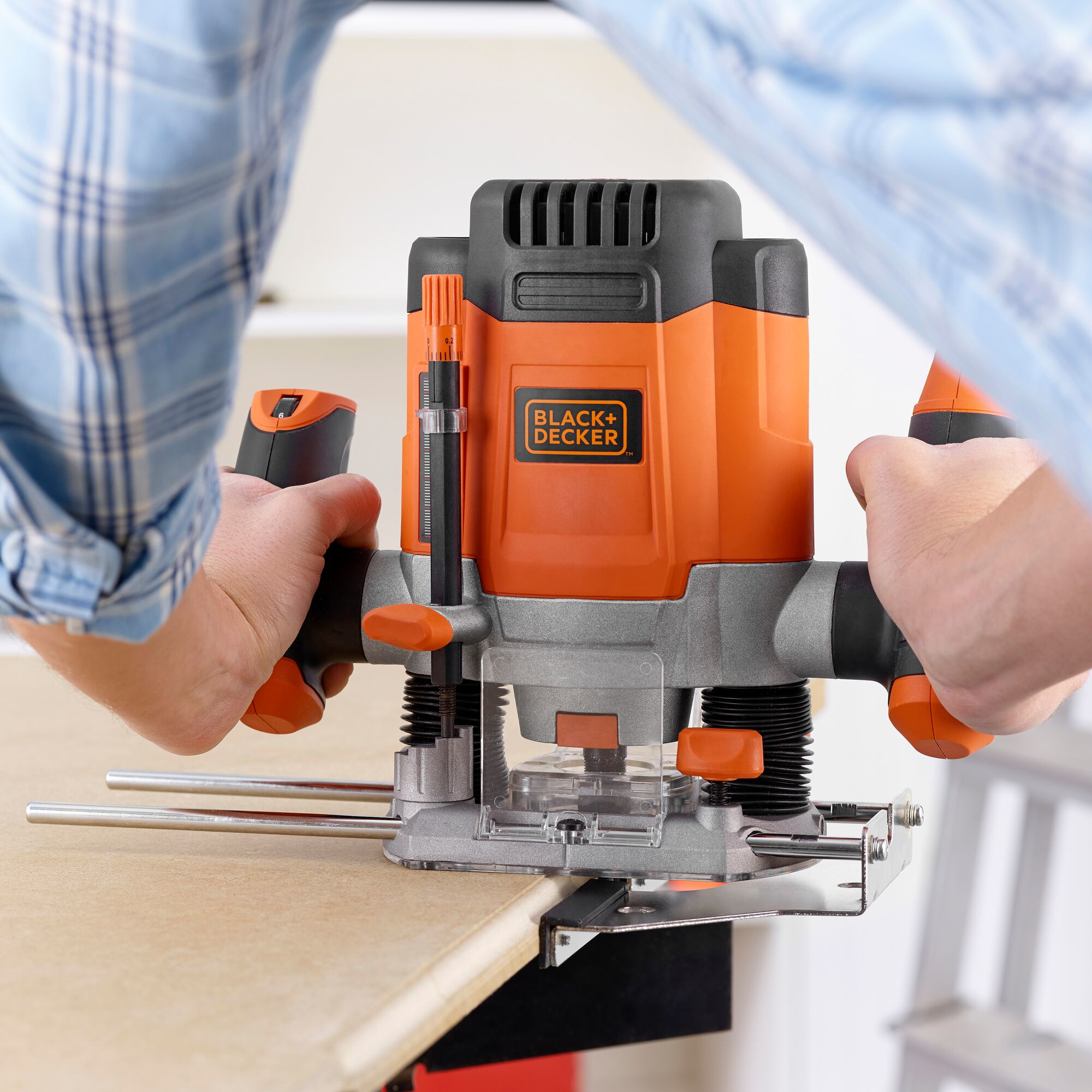 Primer plano de persona usando fresadora Black+Decker para cortar madera.