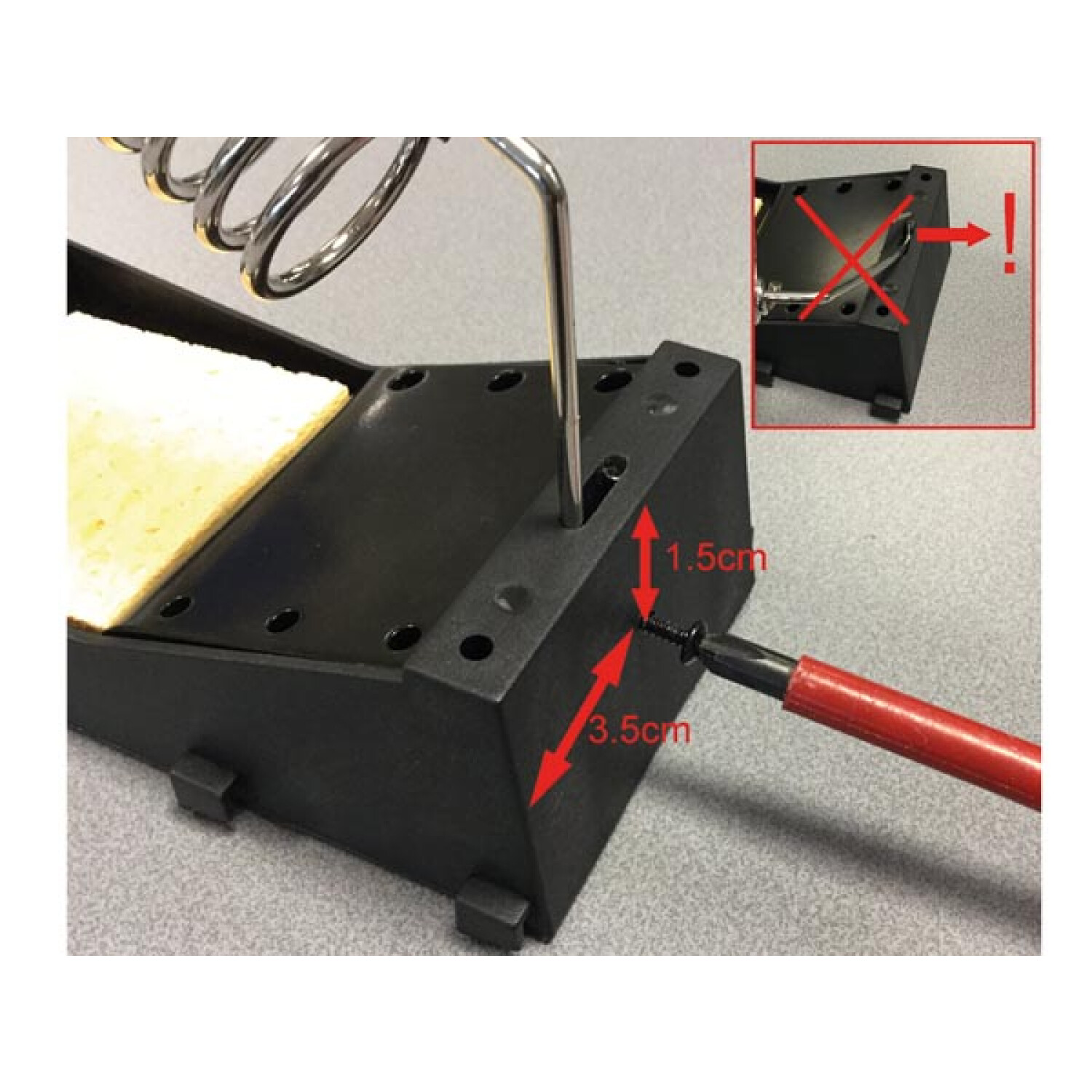 Zbliżenie stojaka lutowniczego ze strzałką wskazującą śrubę.