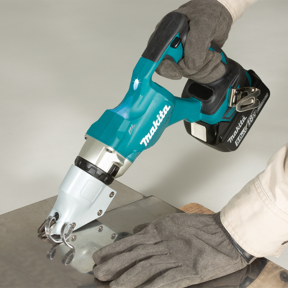 Mani con guanti che usano una cesoia per metalli Makita blu e nera per tagliare il metallo.