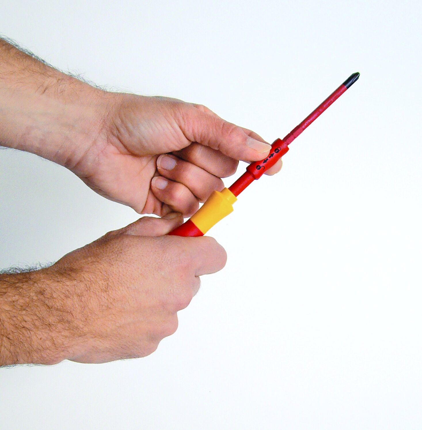 Ręce trzymające czerwono-żółty śrubokręt Wiha.