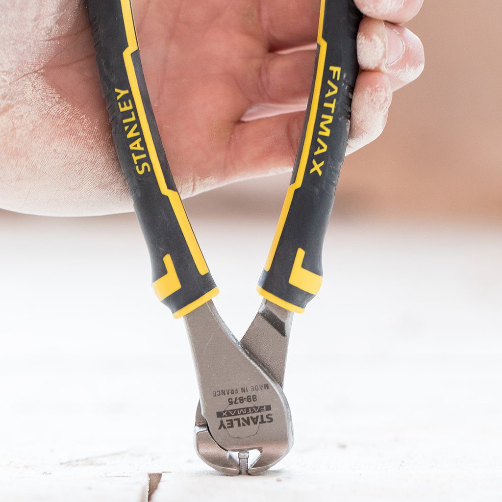 Eine Hand hält eine Stanley Fatmax Seitenschneider. Schwarz-gelbe Griffe mit Aufschrift 'FATMAX' und 'STANLEY'. Silberner Kopf.