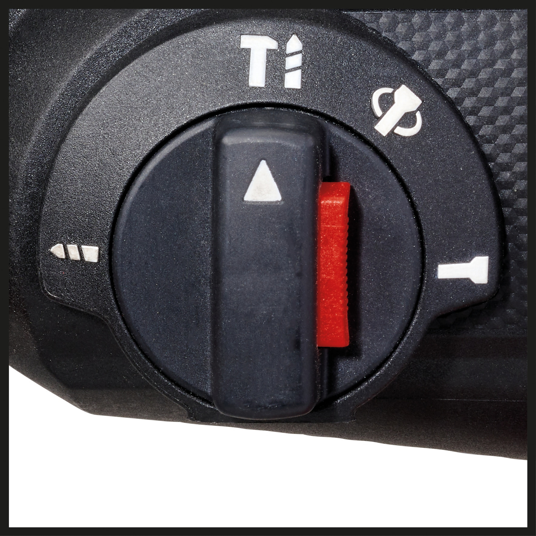 Zbliżenie czarnego pokrętła sterowania wiertarką z białymi i czerwonymi oznaczeniami i symbolami, na teksturowanej czarnej powierzchni.