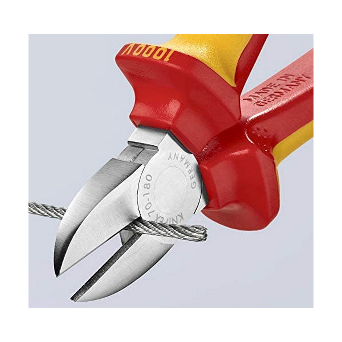 Closeup of cutting pliers cutting a wire, red and yellow handles, white background.