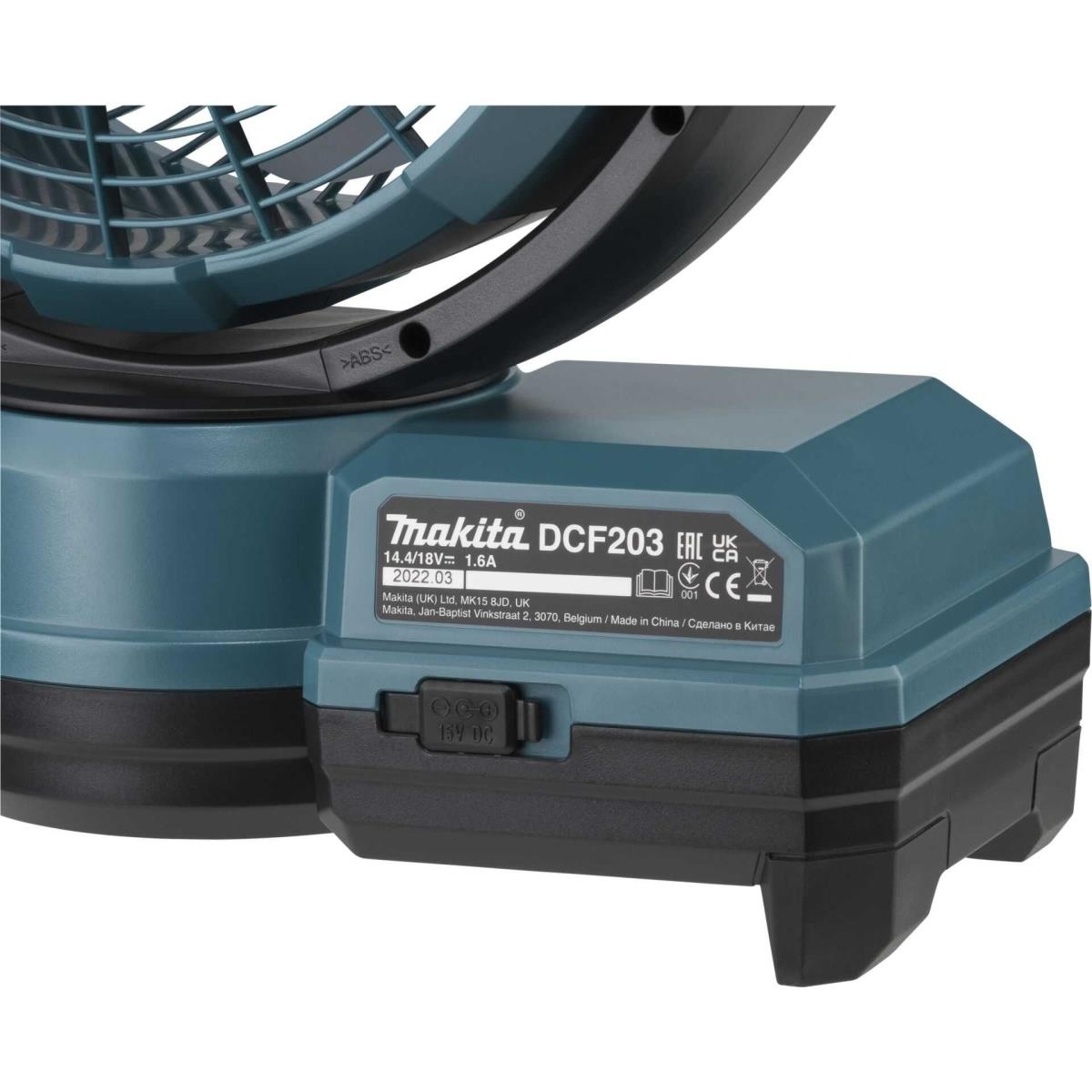Un primer plano de un ventilador azul verdoso con un borde negro. El ventilador está encima de una batería gris con texto.