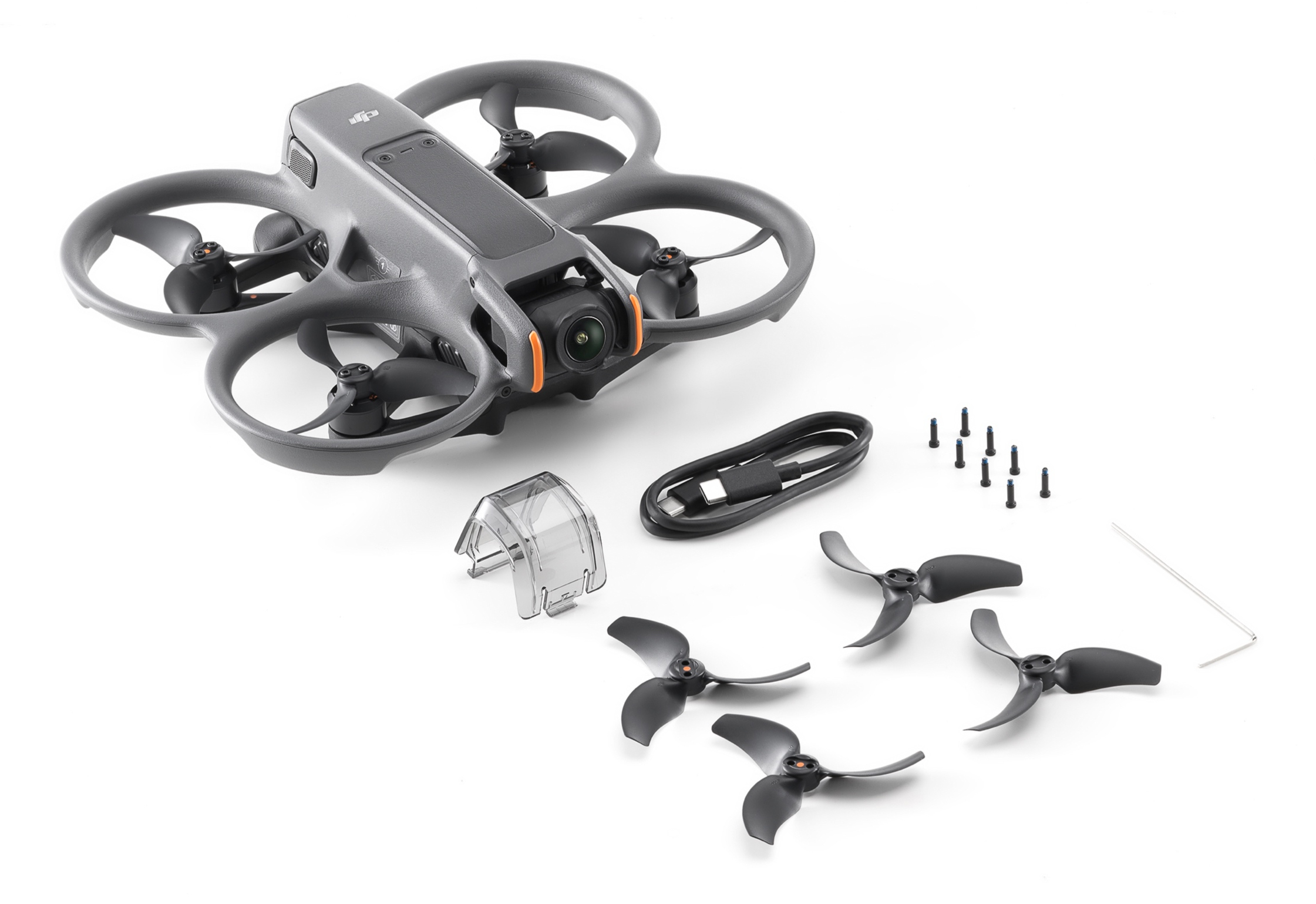 Dron, śmigła, bateria i akcesoria ułożone na białej powierzchni do zdjęcia produktu.