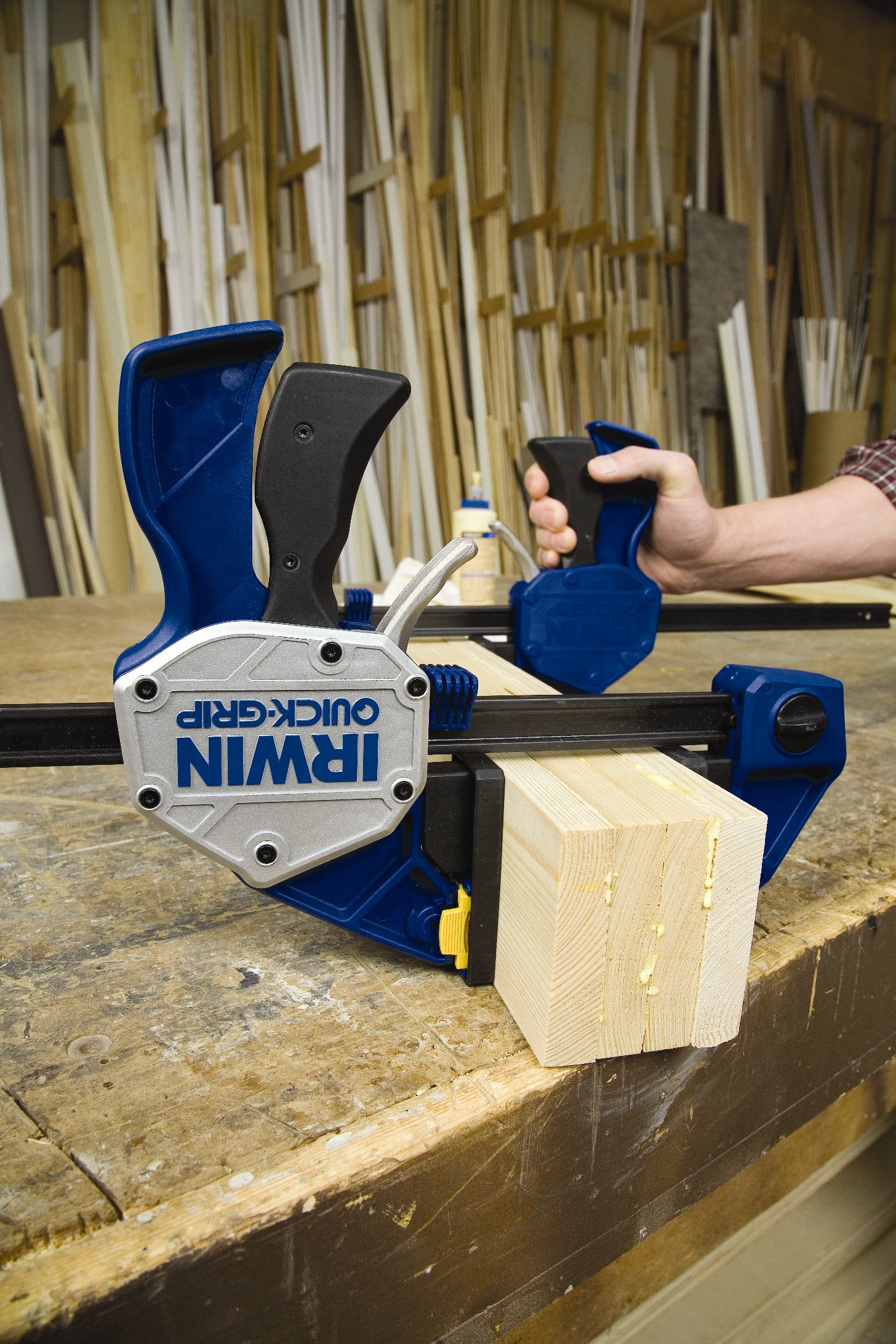 Eine Hand benutzt eine Irwin Quick-Grip Klemme auf einem Holzblock.