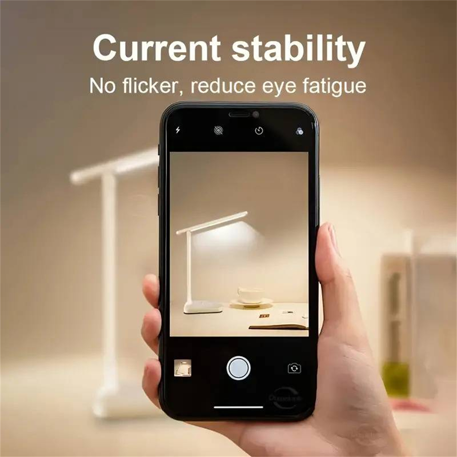 Eine Hand, die ein Telefon mit einer Schreibtischlampe hält. Die Lampe ist eingeschaltet. Dunkler Hintergrund.
