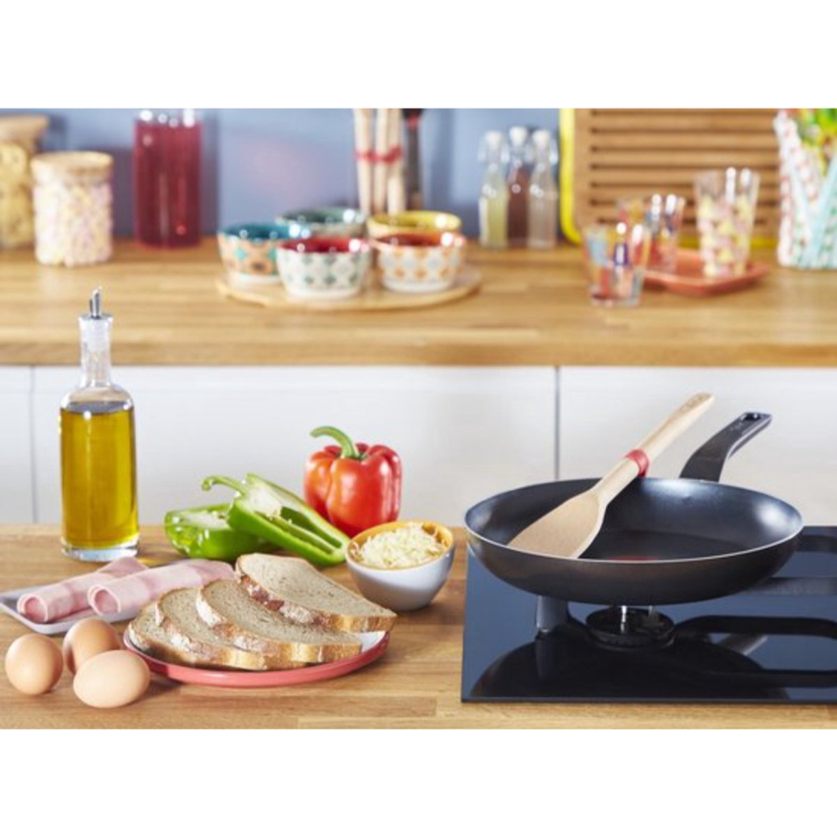 A kitchen scene with ingredients and cooking utensils on a wooden counter.