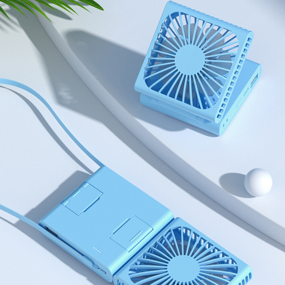 Zwei faltbare, hellblaue tragbare Ventilatoren. Einer ist geöffnet, der andere gefaltet. Eine weiße Kugel ist in der Nähe.