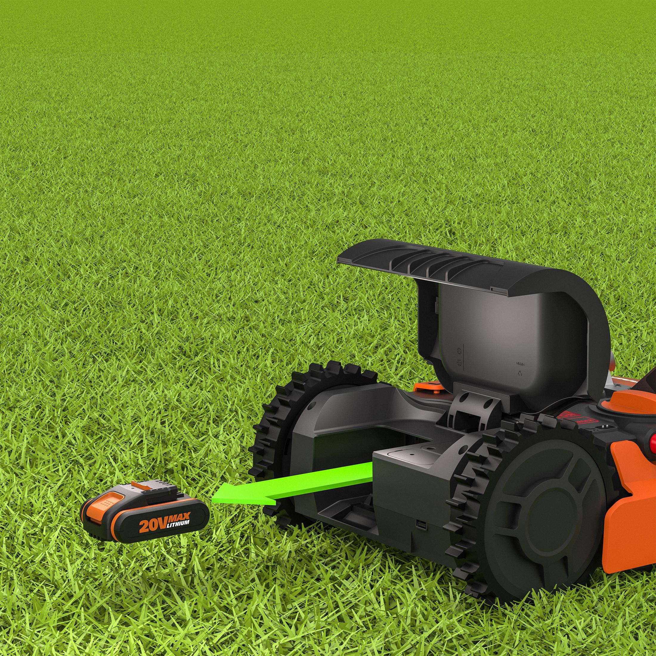 Ein schwarz-oranger Roboterrasenmäher auf grünem Gras. Ein Akku wird eingesetzt, durch grünen Pfeil angezeigt.