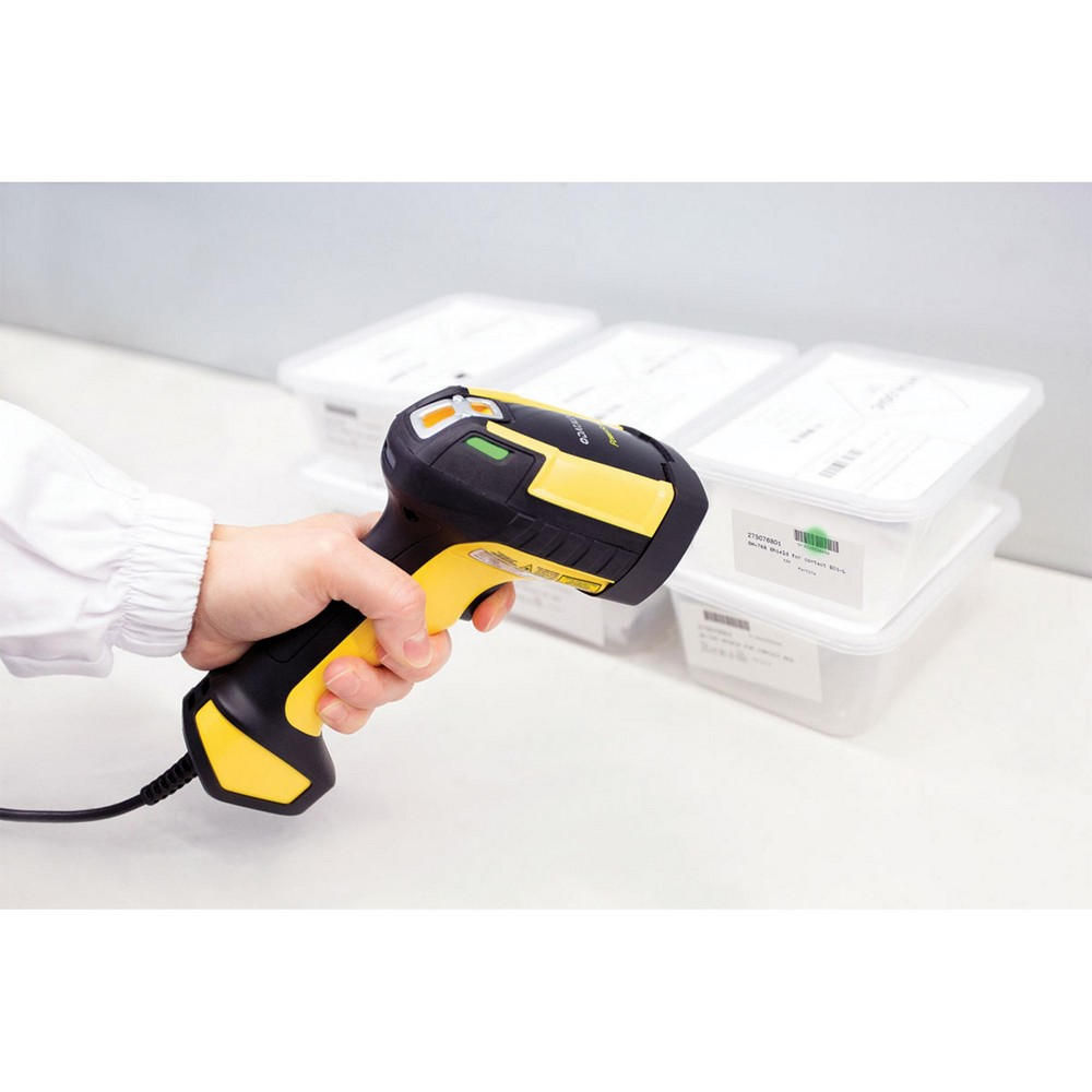 Una persona tiene in mano uno scanner di codici a barre giallo e nero, scansionando un codice a barre su una scatola.