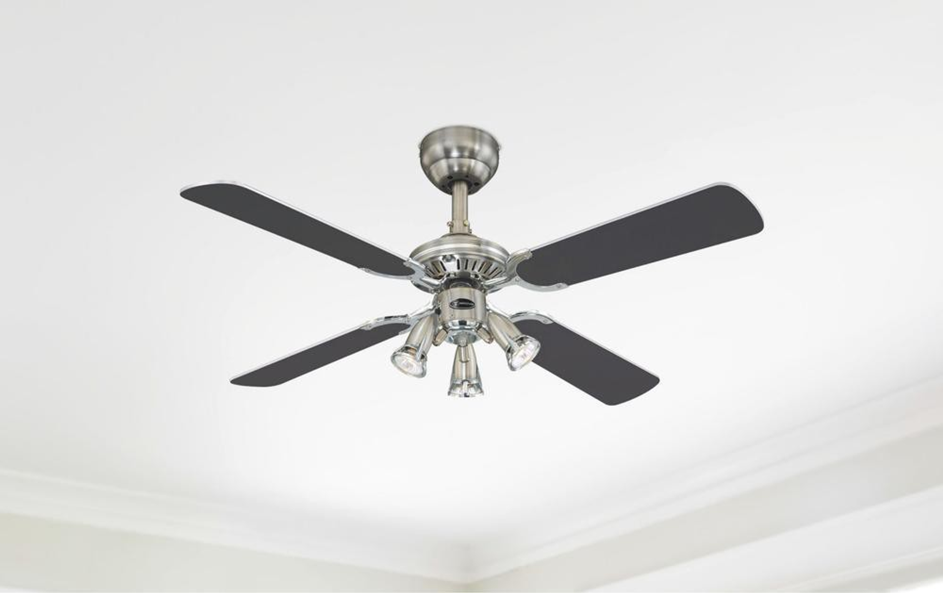 Ventilatore a soffitto con 4 pale nere e tre luci. Sfondo bianco.