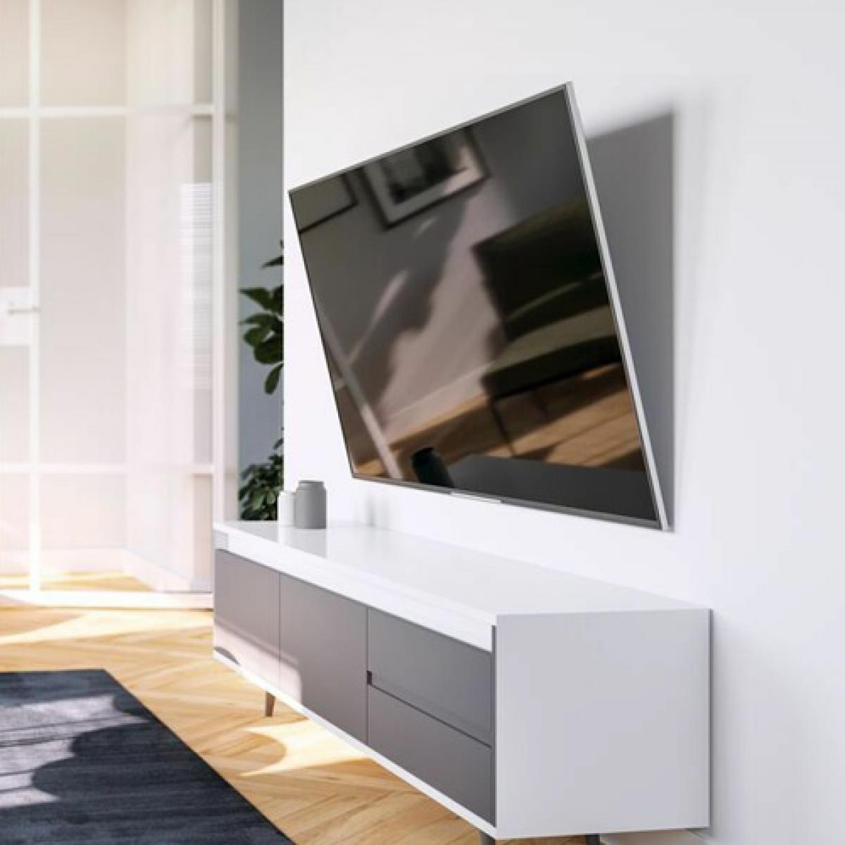Soggiorno moderno con TV a parete, mobile basso bianco con cassetti grigi, pavimento in legno.