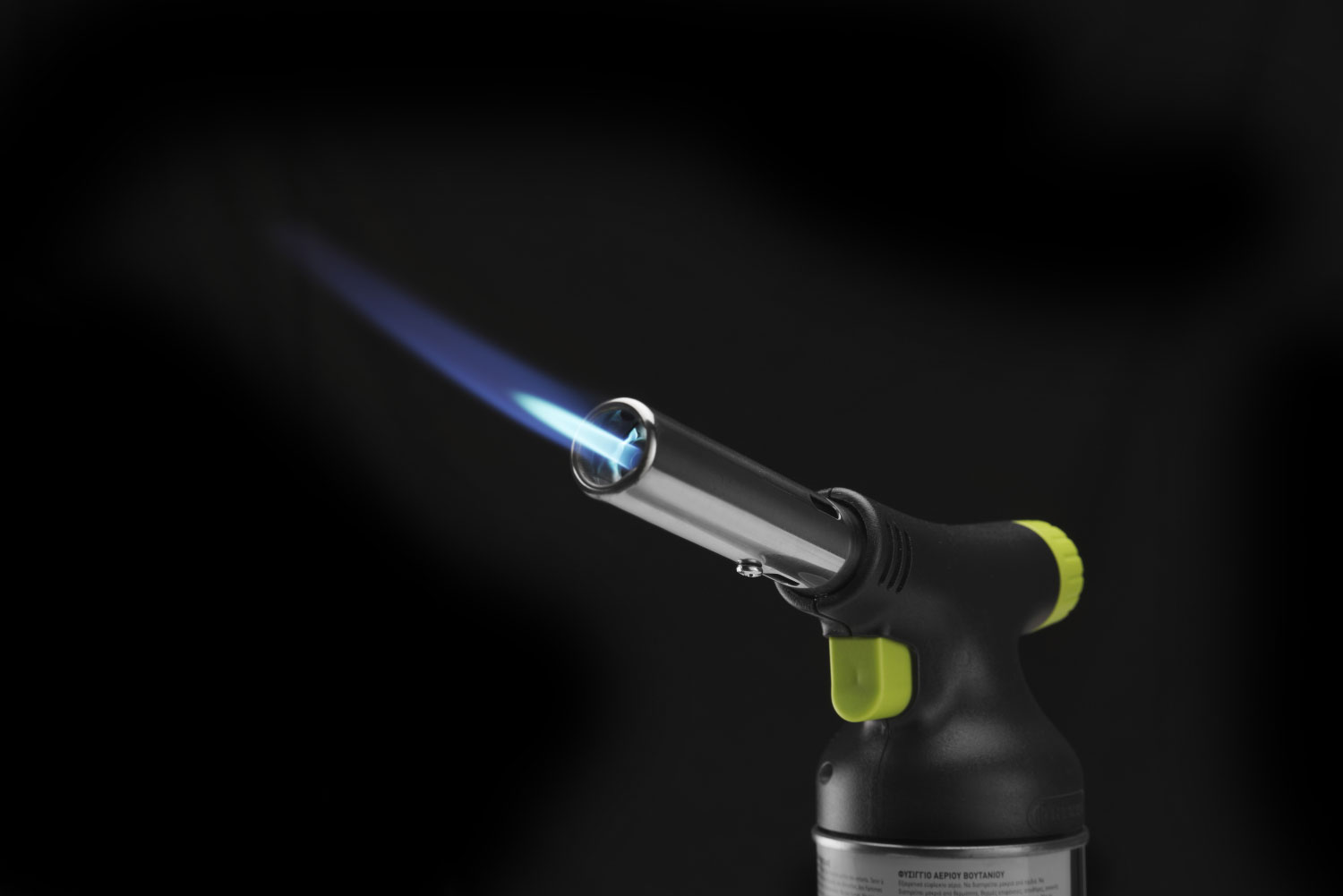 Un cannello a butano nero e argento con fiamma blu su sfondo scuro.