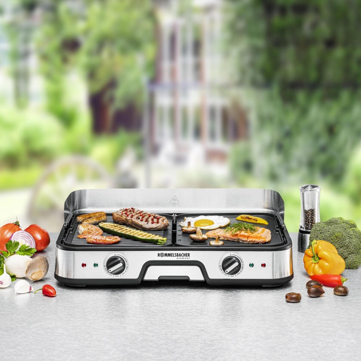 An outdoor grill with food on it, with vegetables and herbs around it.