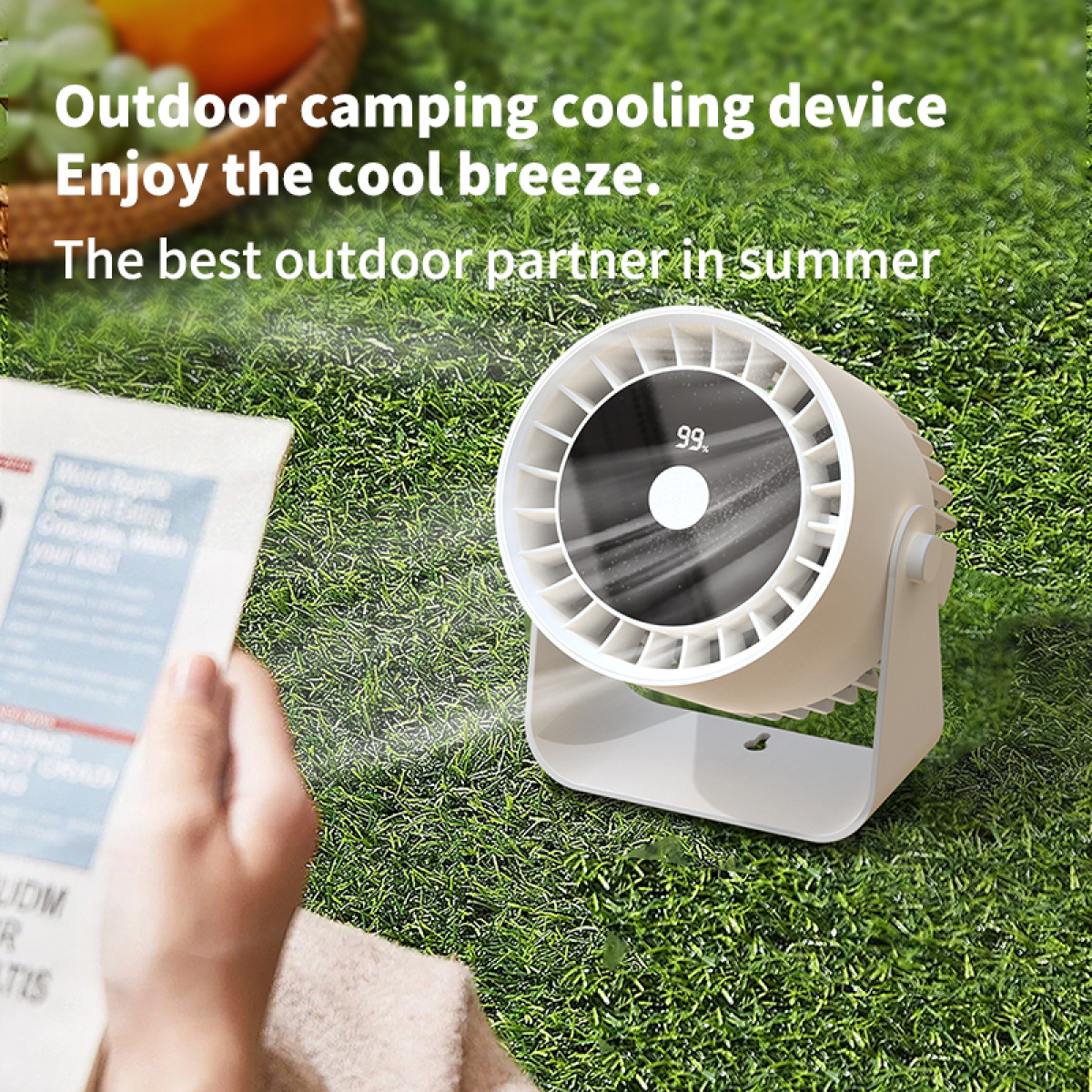 White and black portable fan on grass. Text: Outdoor camping cooling device.