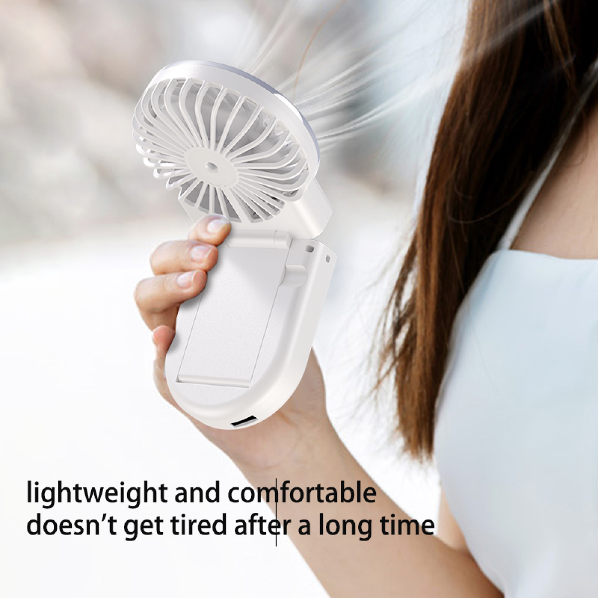 White portable fan held by a person, text says it's lightweight and comfortable.