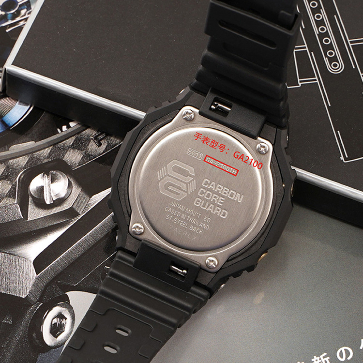 Rückseite einer schwarzen G-Shock-Uhr. Text: Carbon Core Guard, GA-2100 und weitere Details.