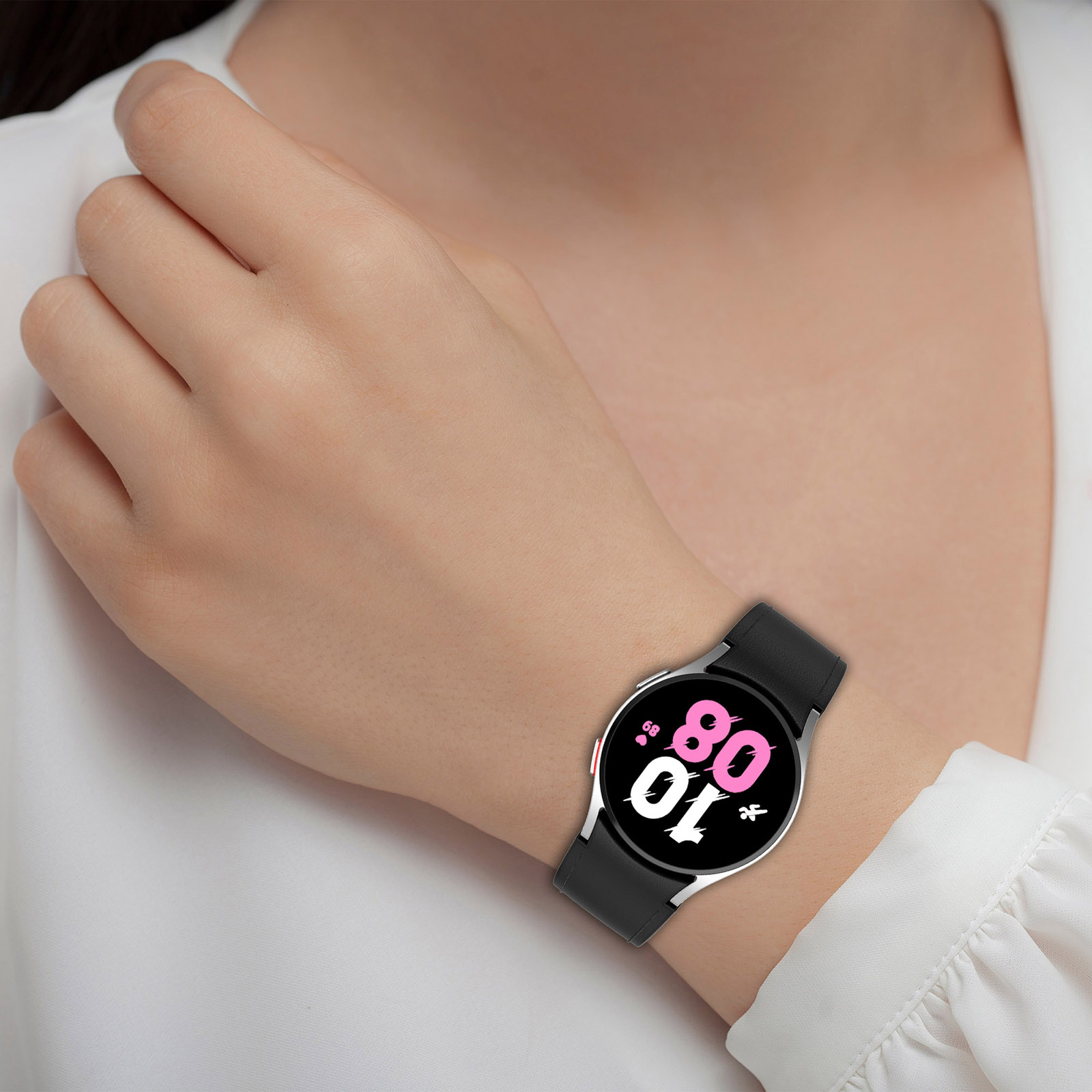 Handgelenk einer Frau mit schwarzer Smartwatch. Die Uhr hat ein schwarzes Armband und pinkfarbenes Display.