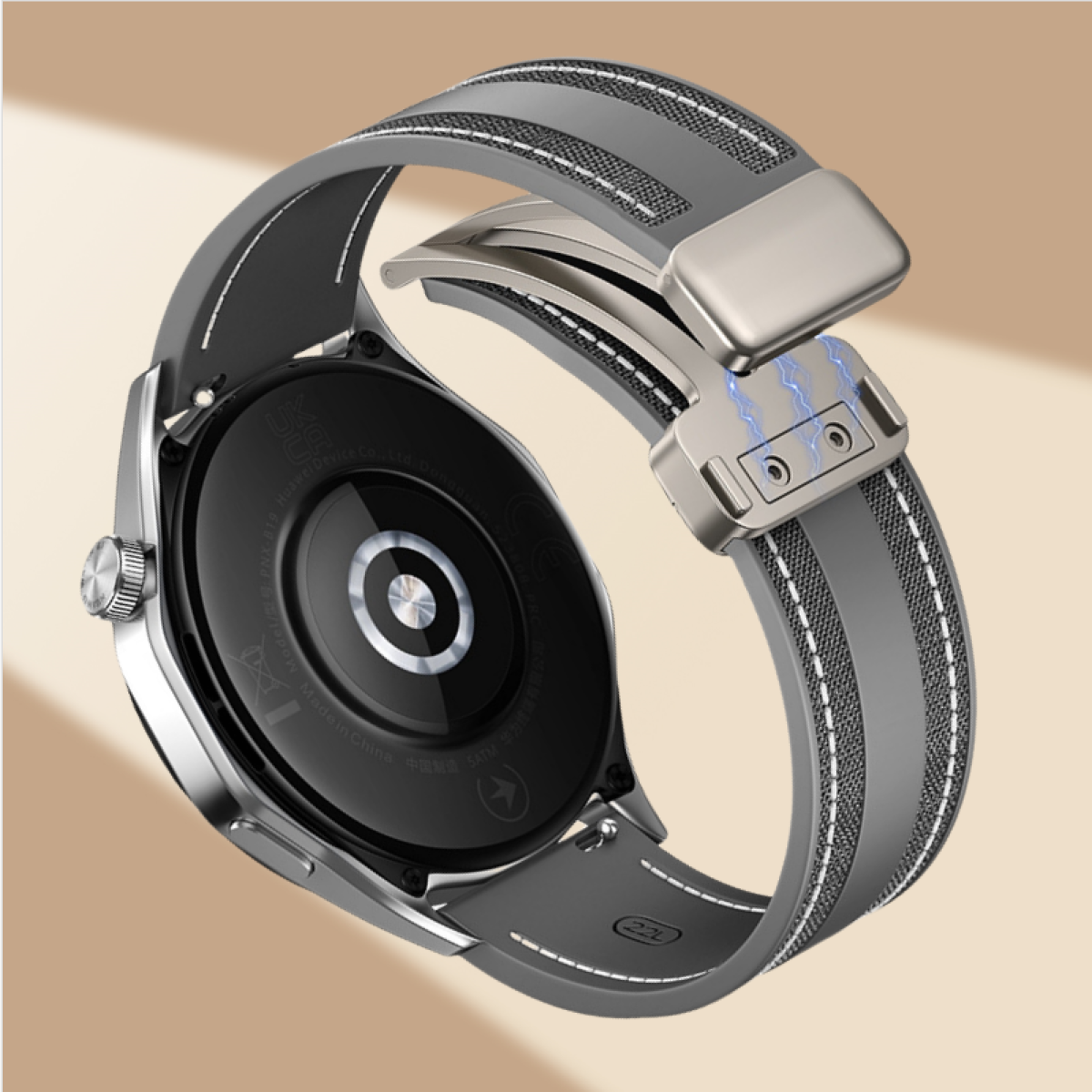 Uno smartwatch con cinturino grigio. Il cinturino è aperto, mostrando una chiusura magnetica.