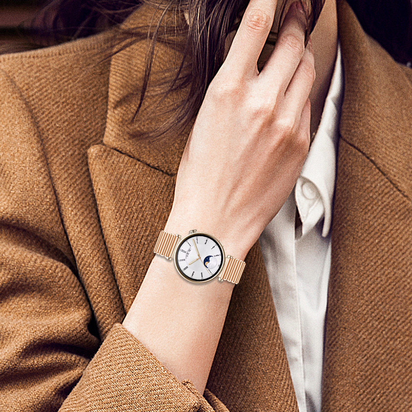 Polso di donna con orologio oro rosa, quadrante bianco e display delle fasi lunari.