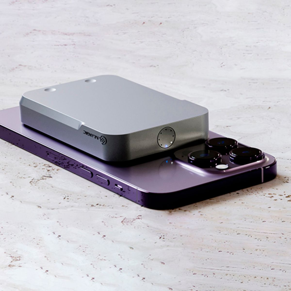 Un dispositivo argentato su un telefono viola su una superficie chiara. Il marchio è visibile.