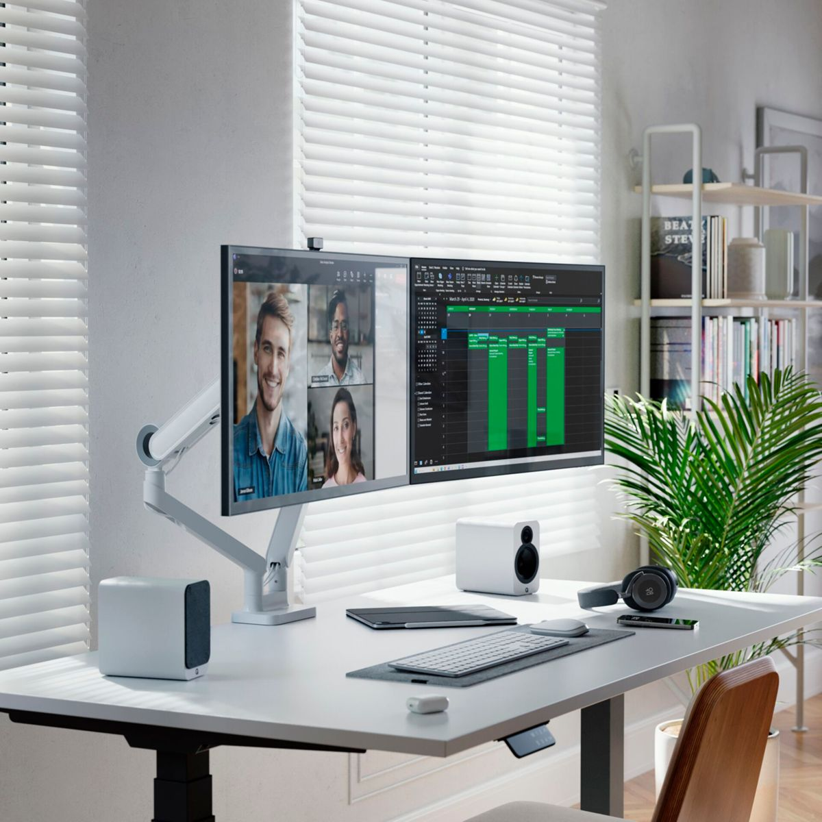 Modernes Büro-Setup mit zwei Monitoren, die Videoanrufe anzeigen, Tastatur, Lautsprechern und Schreibtisch.