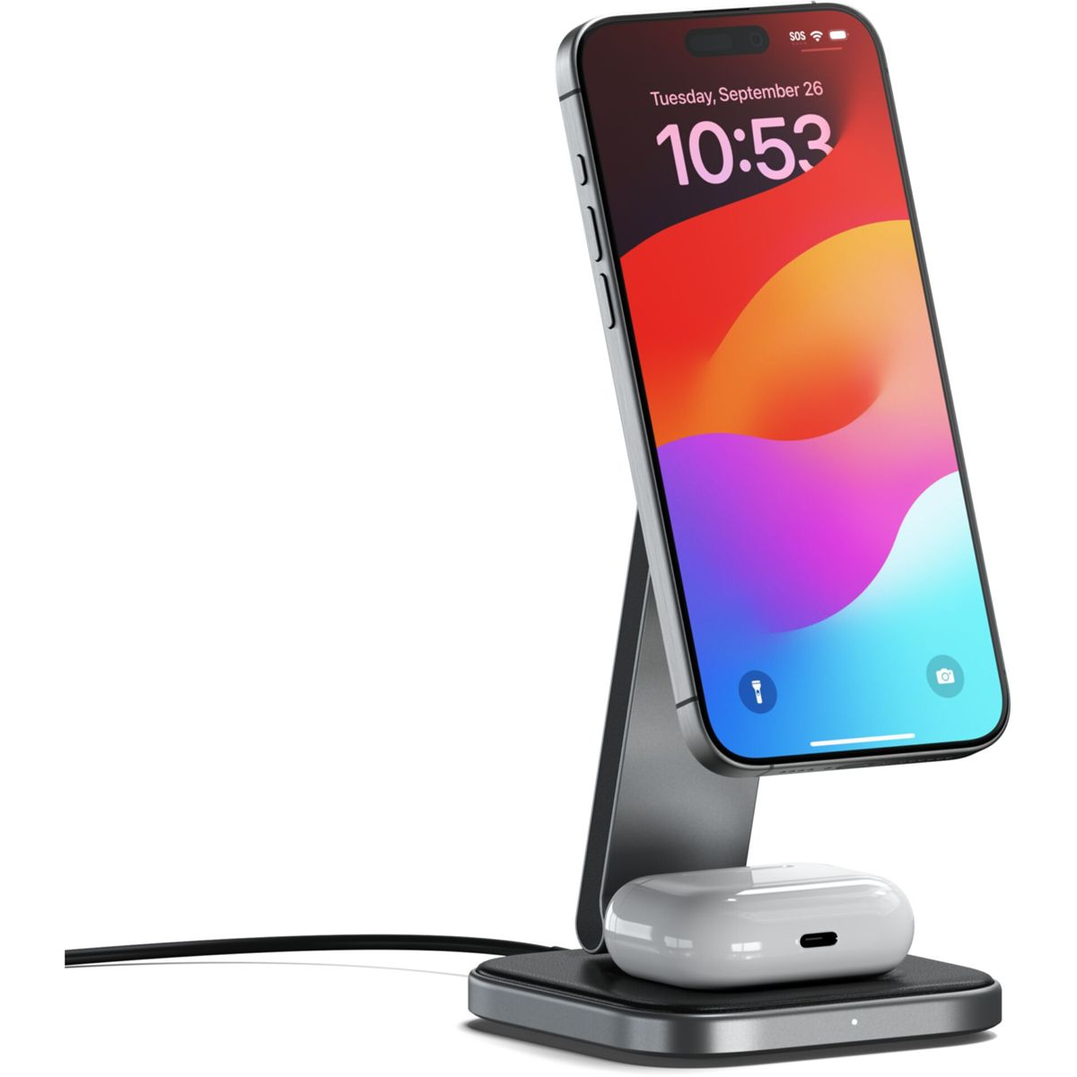 Ein Smartphone auf einem Ständer, das mit drahtlosen Ohrhörern darunter aufgeladen wird, auf einem Schreibtisch.