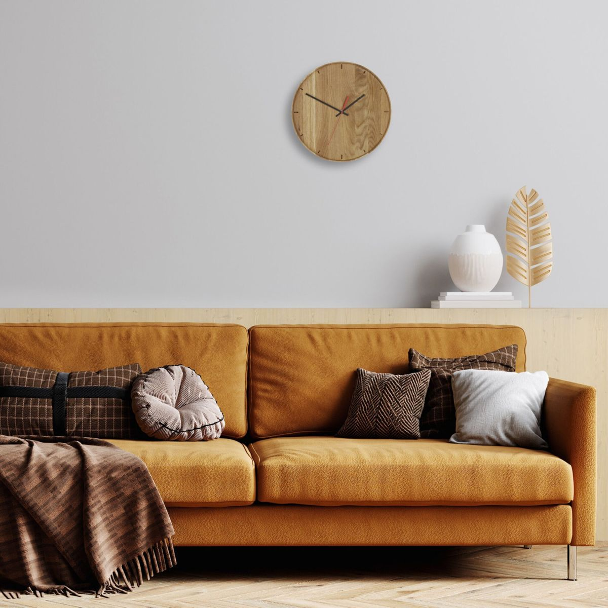 Eine orangefarbene Couch mit Kissen und Decke, eine Uhr an der Wand und dekorative Gegenstände.