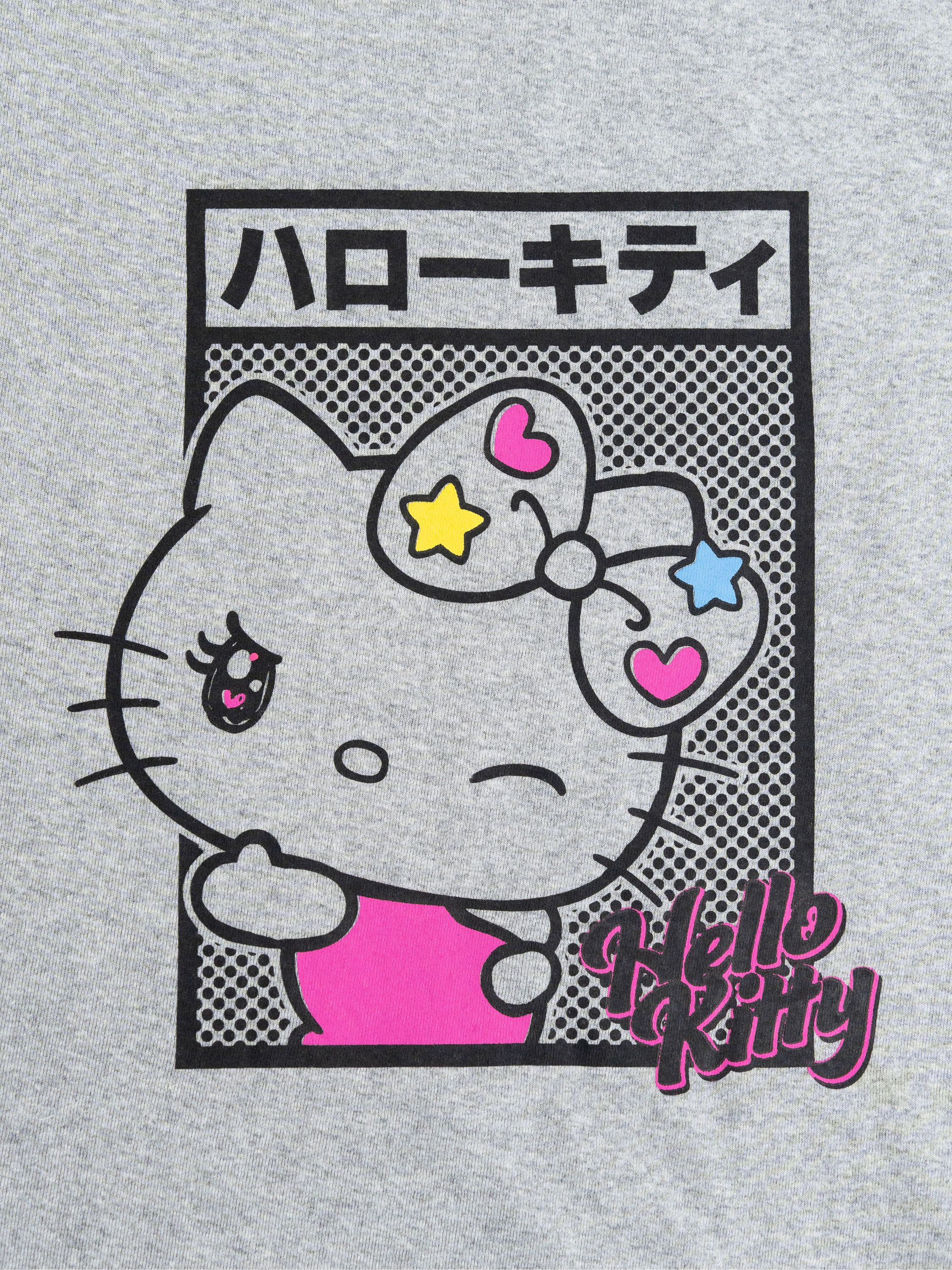 Graues T-Shirt mit Hello Kitty-Grafik. Japanischer Text und Sterne.