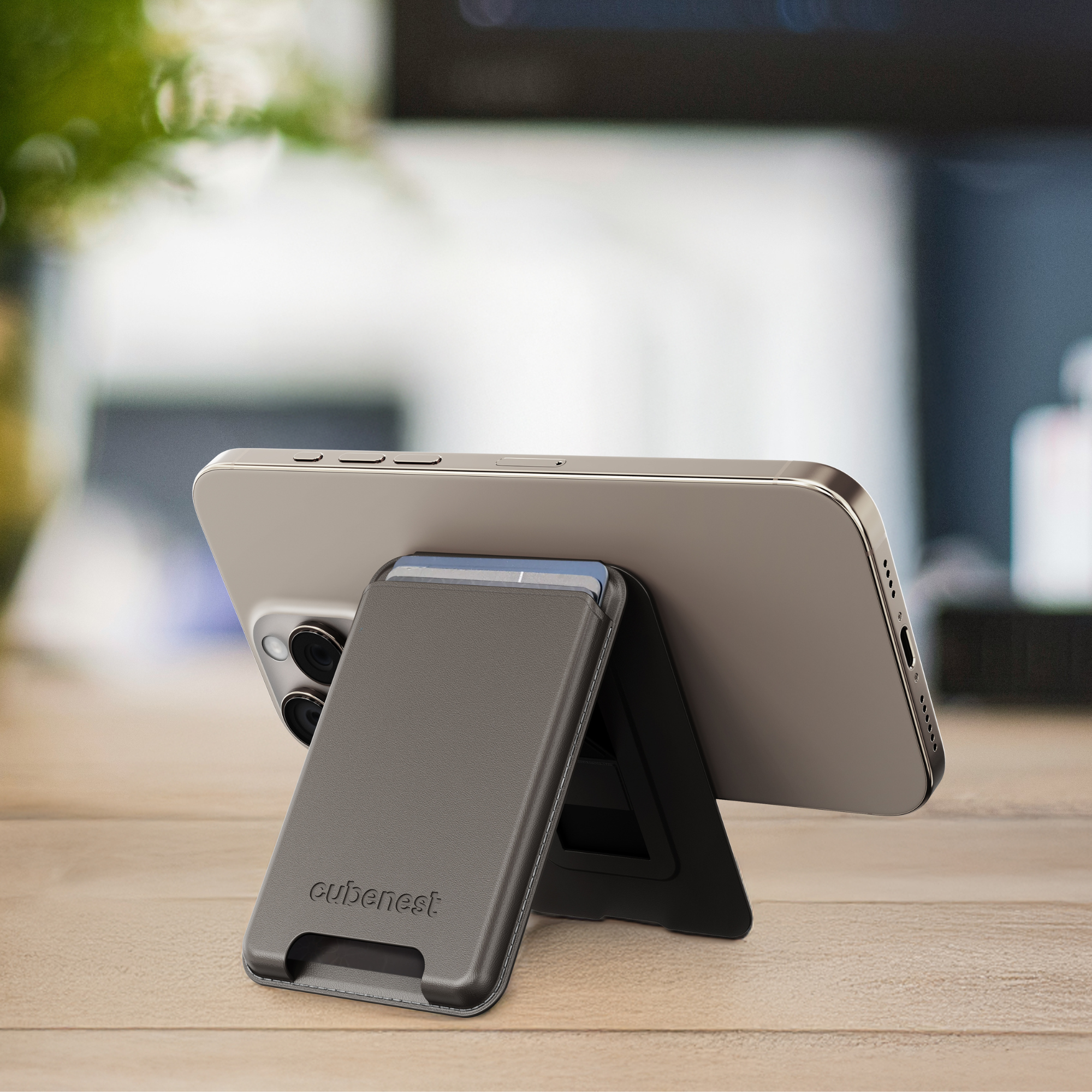 Telefon in grauem Ständer. Der Ständer hat einen schwarzen Fuß und einen Kartenhalter.