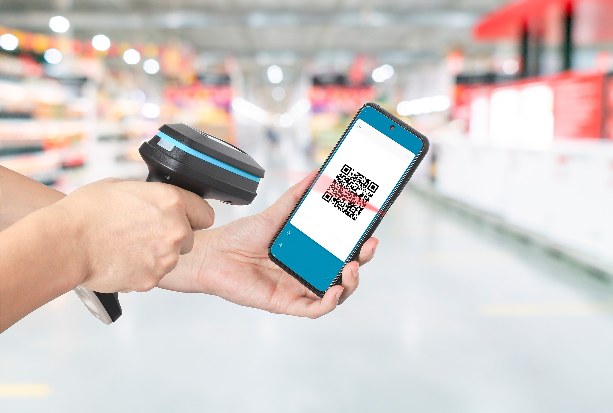 Una persona che scansiona un codice QR sullo schermo di un telefono con un lettore di codici a barre.