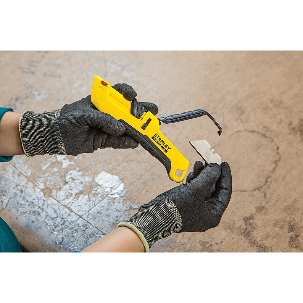 Hände in Handschuhen halten ein gelbes Universalmesser und entfernen eine Klinge.