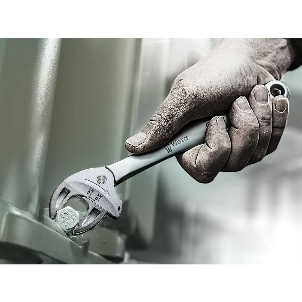 Hand hält einen Schraubenschlüssel, der an einer Schraube befestigt ist. Der Schraubenschlüssel ist grau und silber.