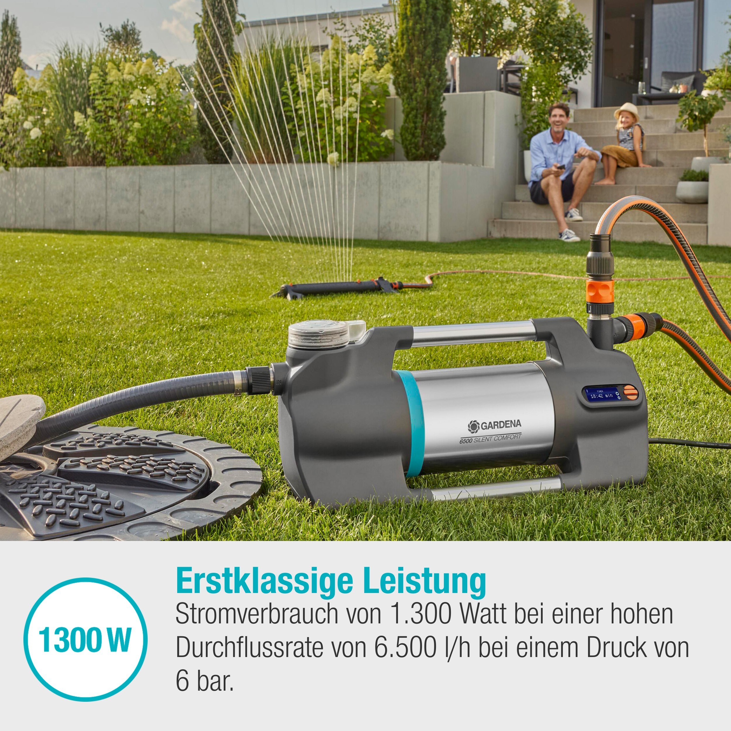 Pompa wodna podlewająca trawnik. Mężczyzna i dziecko w tle, na trawniku.