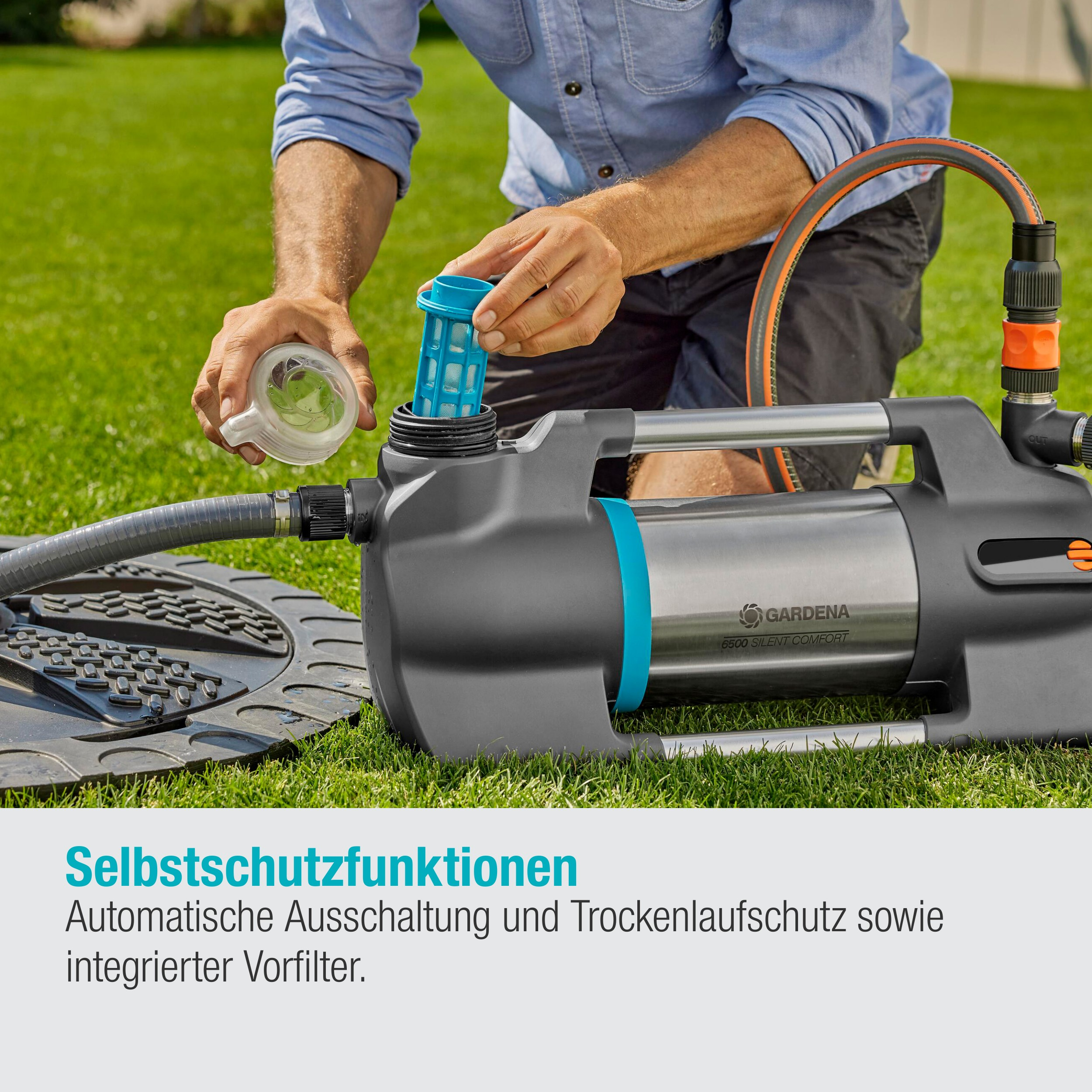 Mężczyzna montuje pompę wodną. Pompa jest szara i srebrna. Tło to trawa.