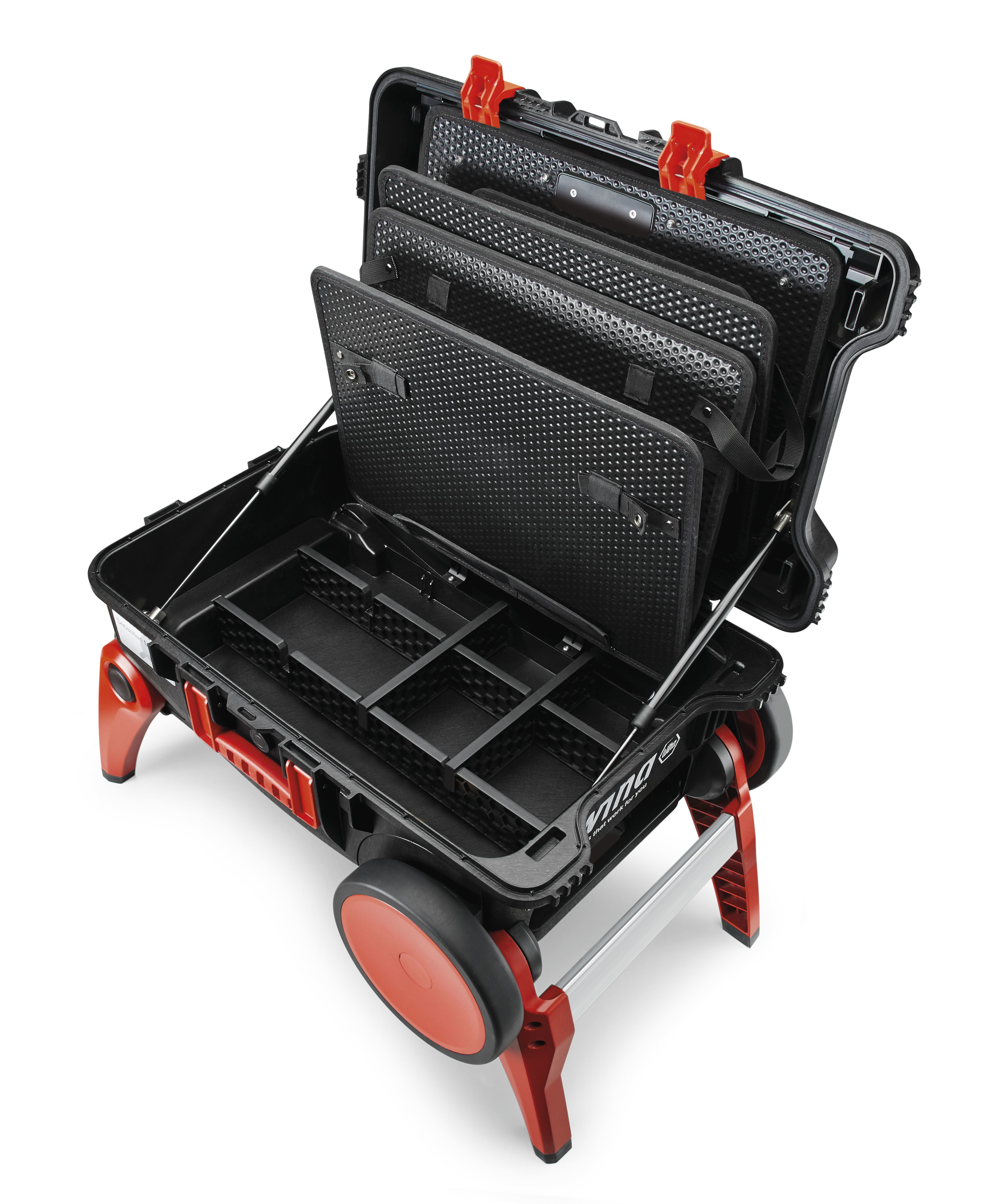 Caja de herramientas abierta con compartimentos negros, detalles rojos y ruedas rojas. Contiene herramientas, con bandejas abiertas, sobre fondo blanco.