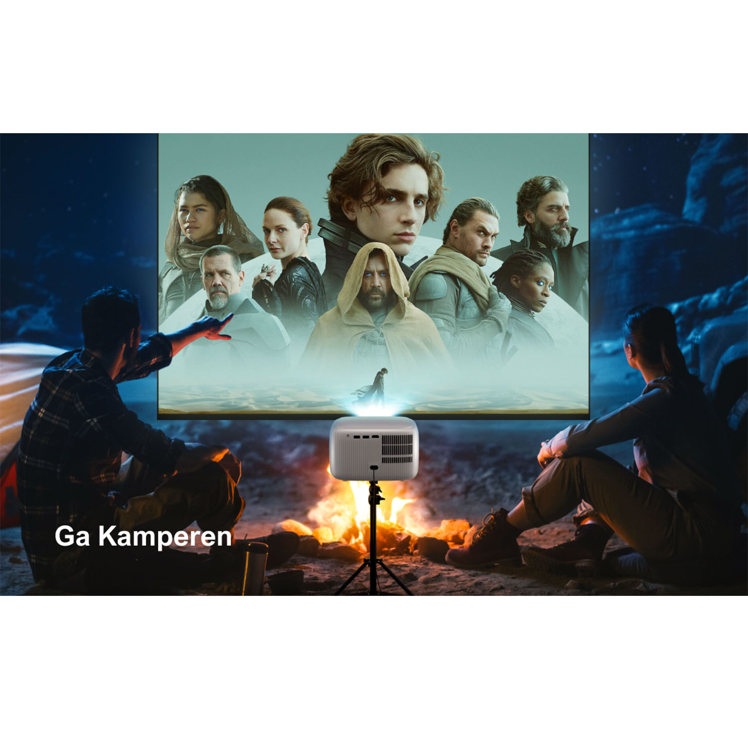 Des gens regardent un film projeté sur un écran. Un projecteur est devant un feu.