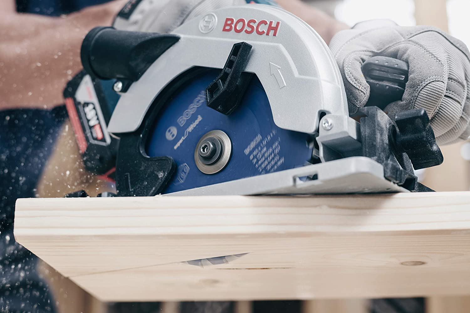Ein Arbeiter schneidet mit einer Kreissäge ein Holzbrett. Eine BOSCH-Säge wird verwendet.
