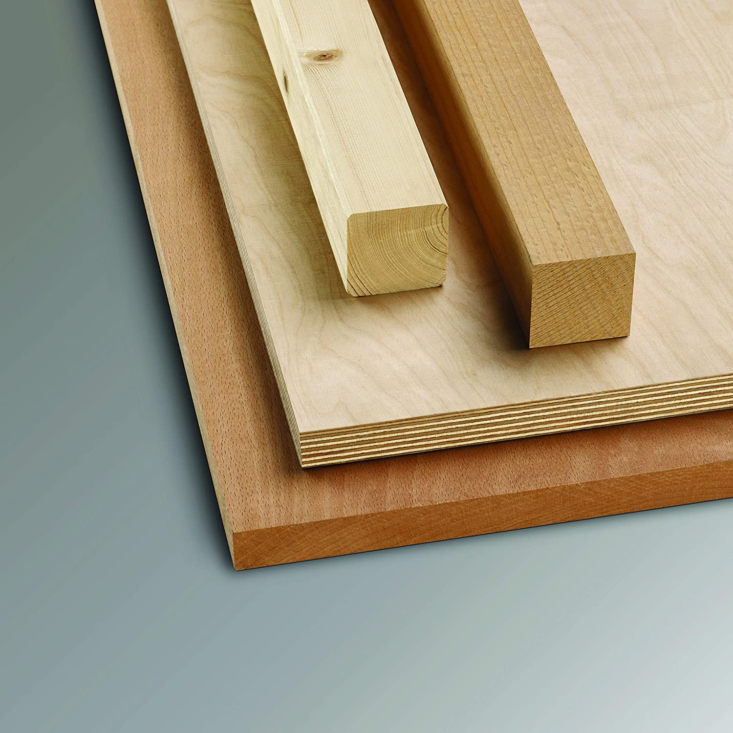 Holzbretter: ein helles Quadrat, ein dunkleres und ein langes, rechteckiges Stück. Grauer Hintergrund.